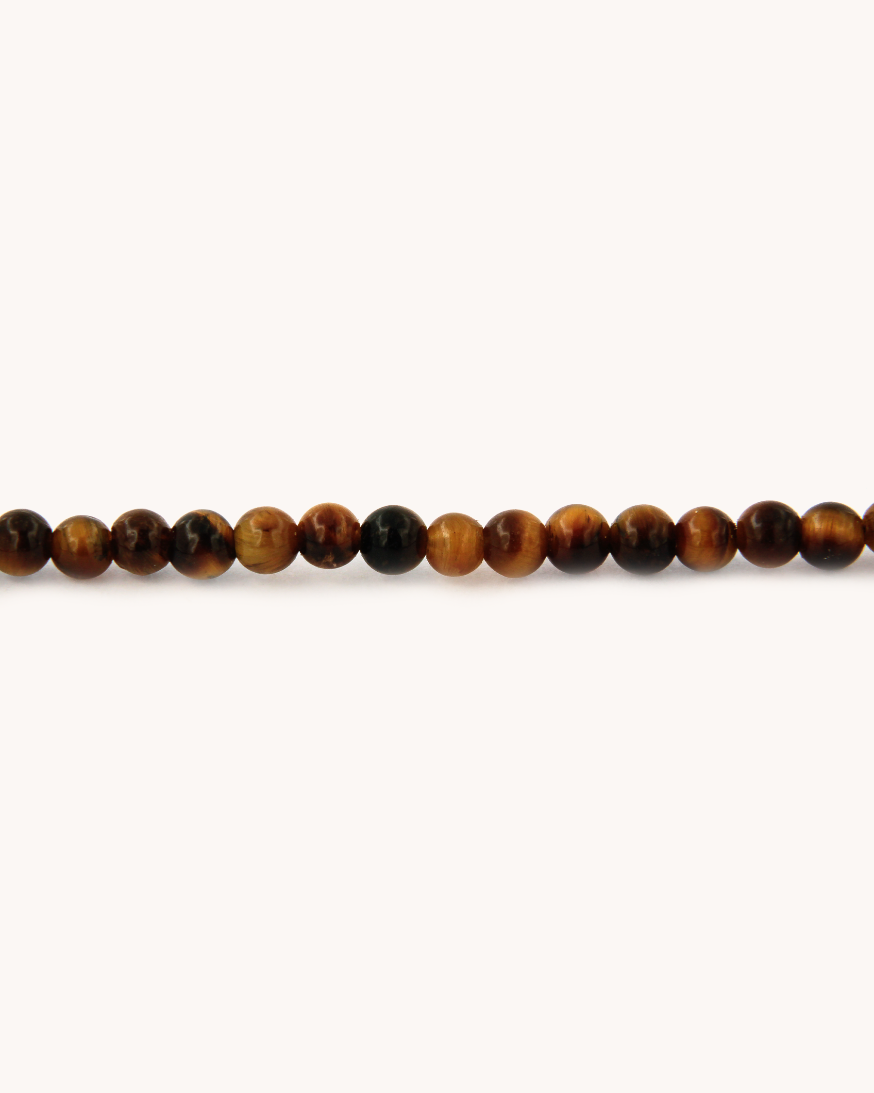 Dettaglio della collana Coloris con perline di occhio di tigre e piastra con rosa dipinta a mano in smalto a fuoco, incorniciata in oro giallo 18 carati.