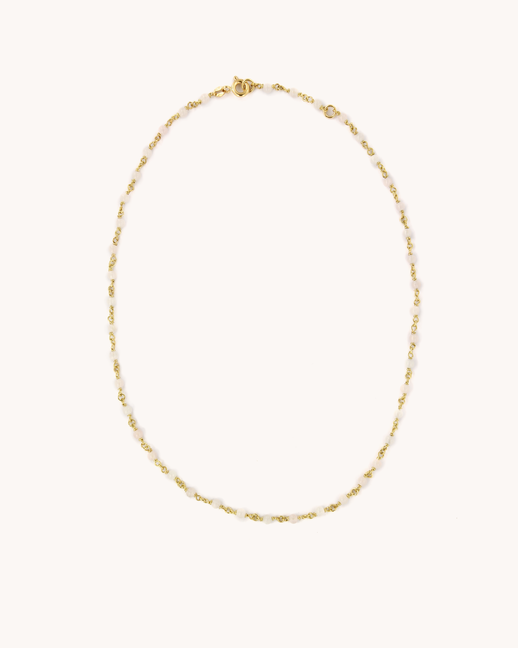 Collana Mediterraneo base in oro giallo 18 carati, impreziosita da perline naturali di quarzo rosa.