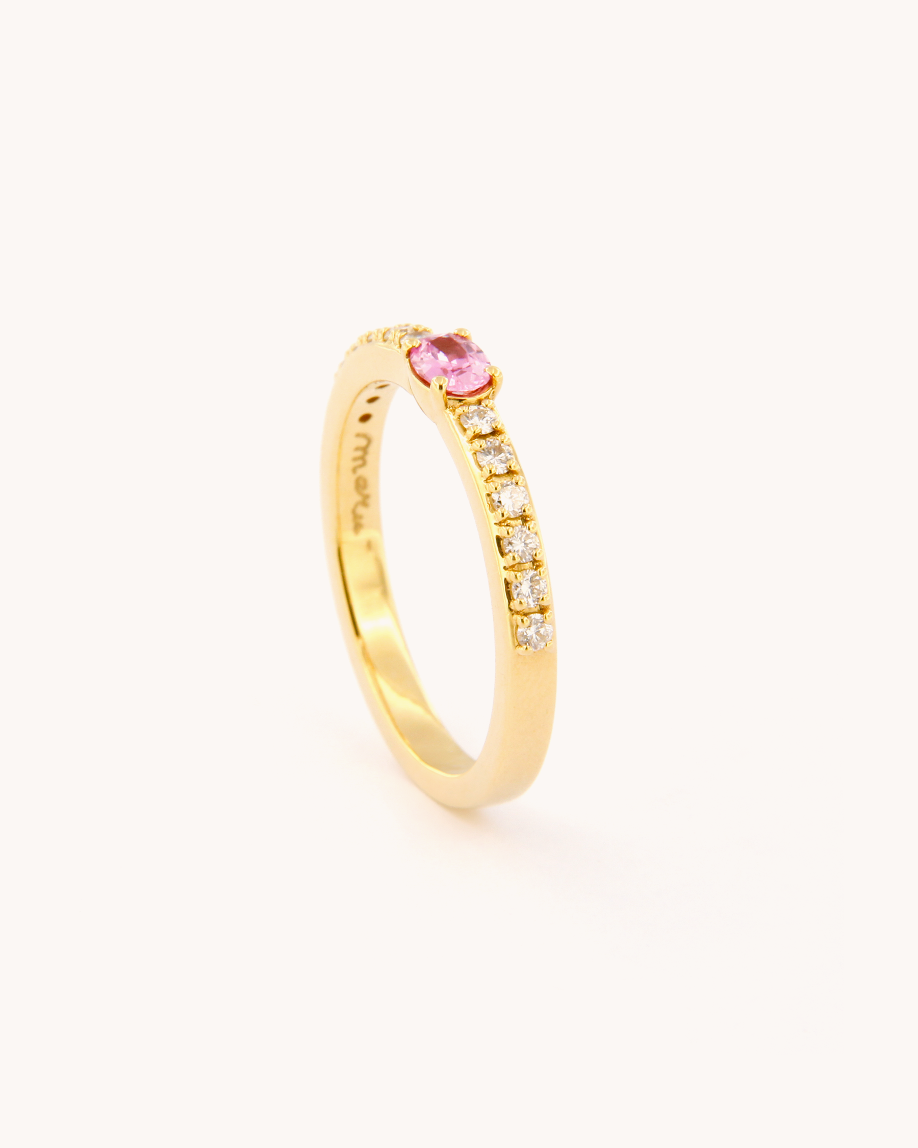 Anello oro 18K con zaffiro rosa ovale centrale e diamanti laterali.