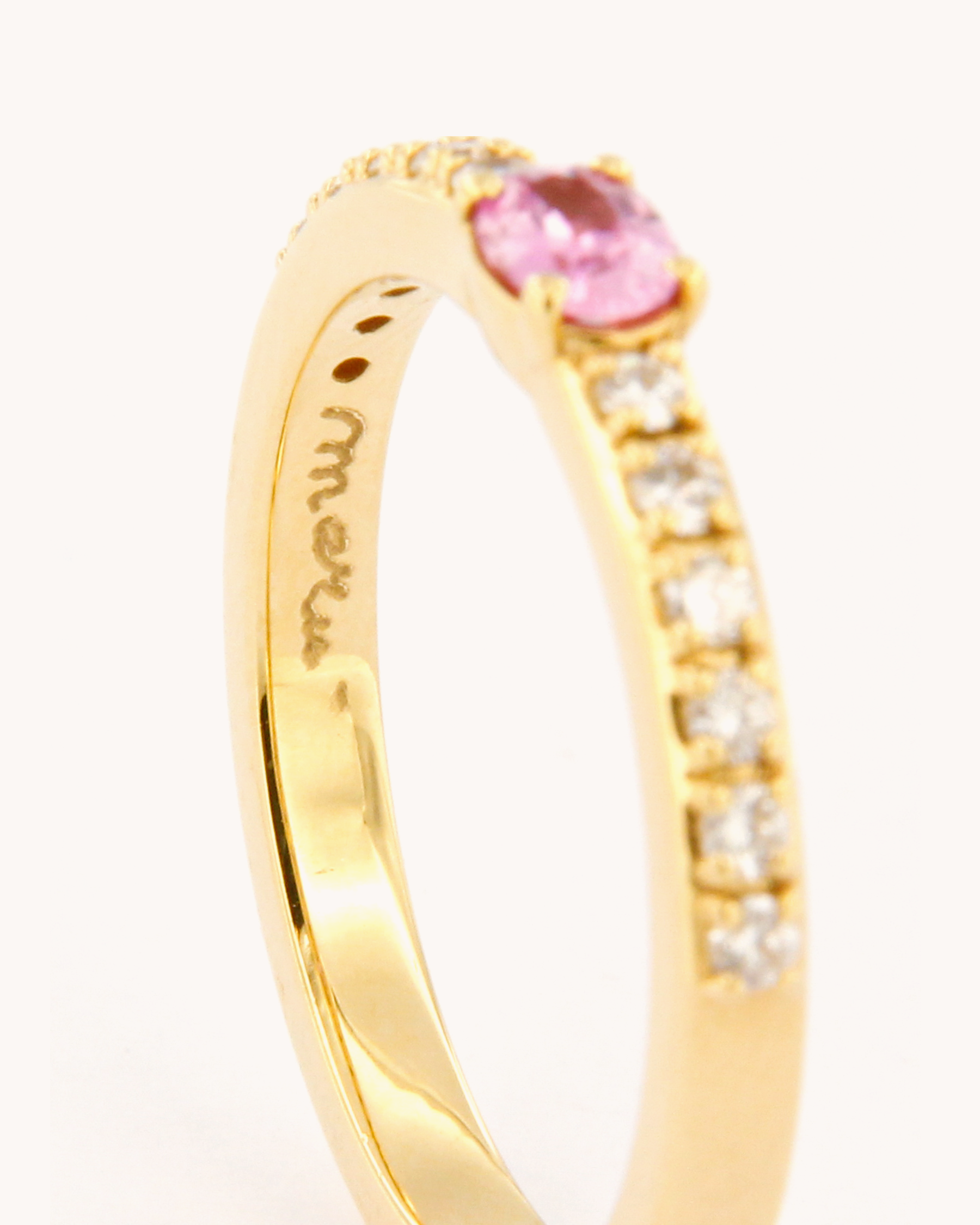 Anello oro 18K con zaffiro rosa ovale centrale e diamanti laterali.