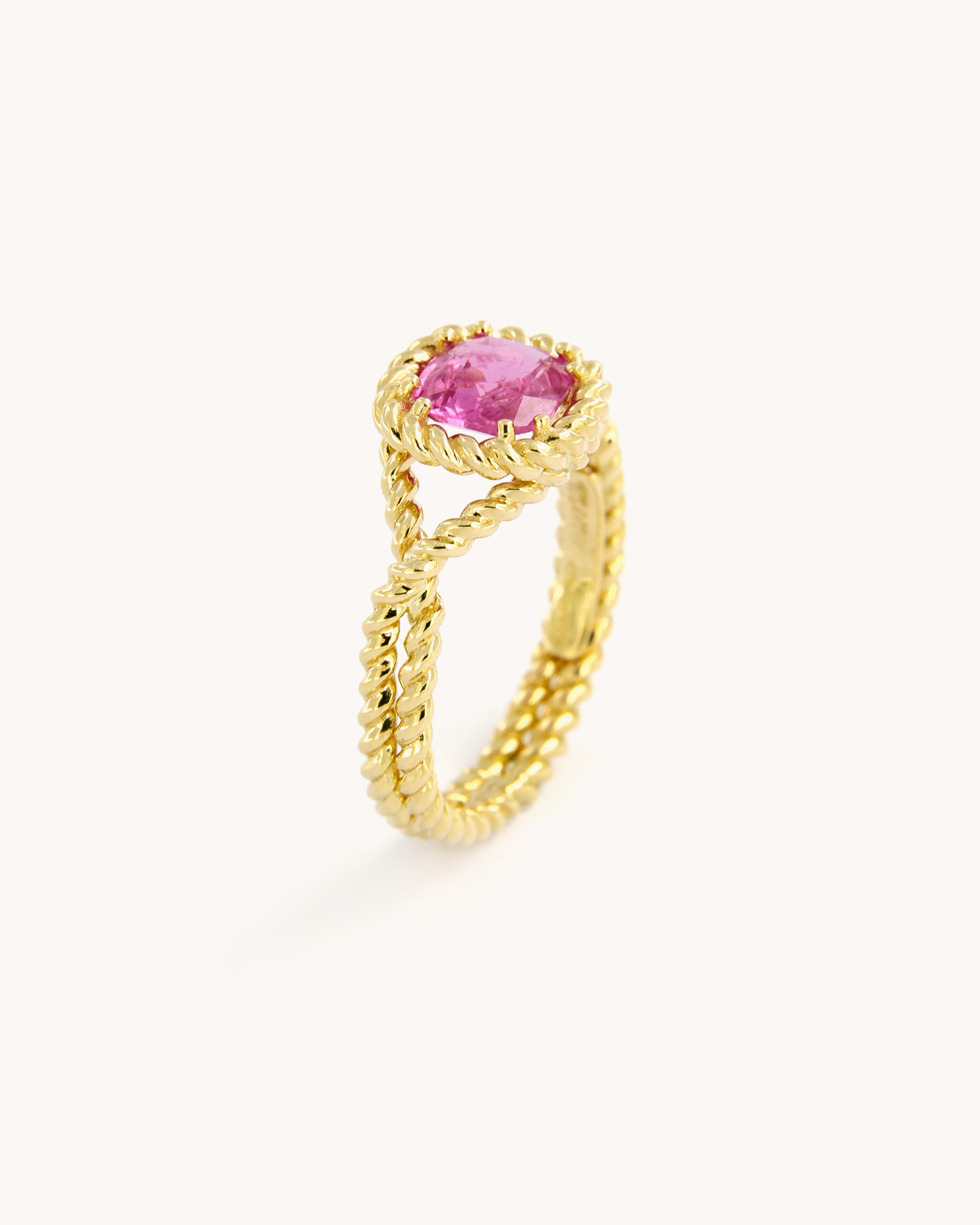 Anello Torchon in oro giallo 18 carati con zaffiro rosa naturale, incastonato in una montatura con lavorazione a corda intrecciata.