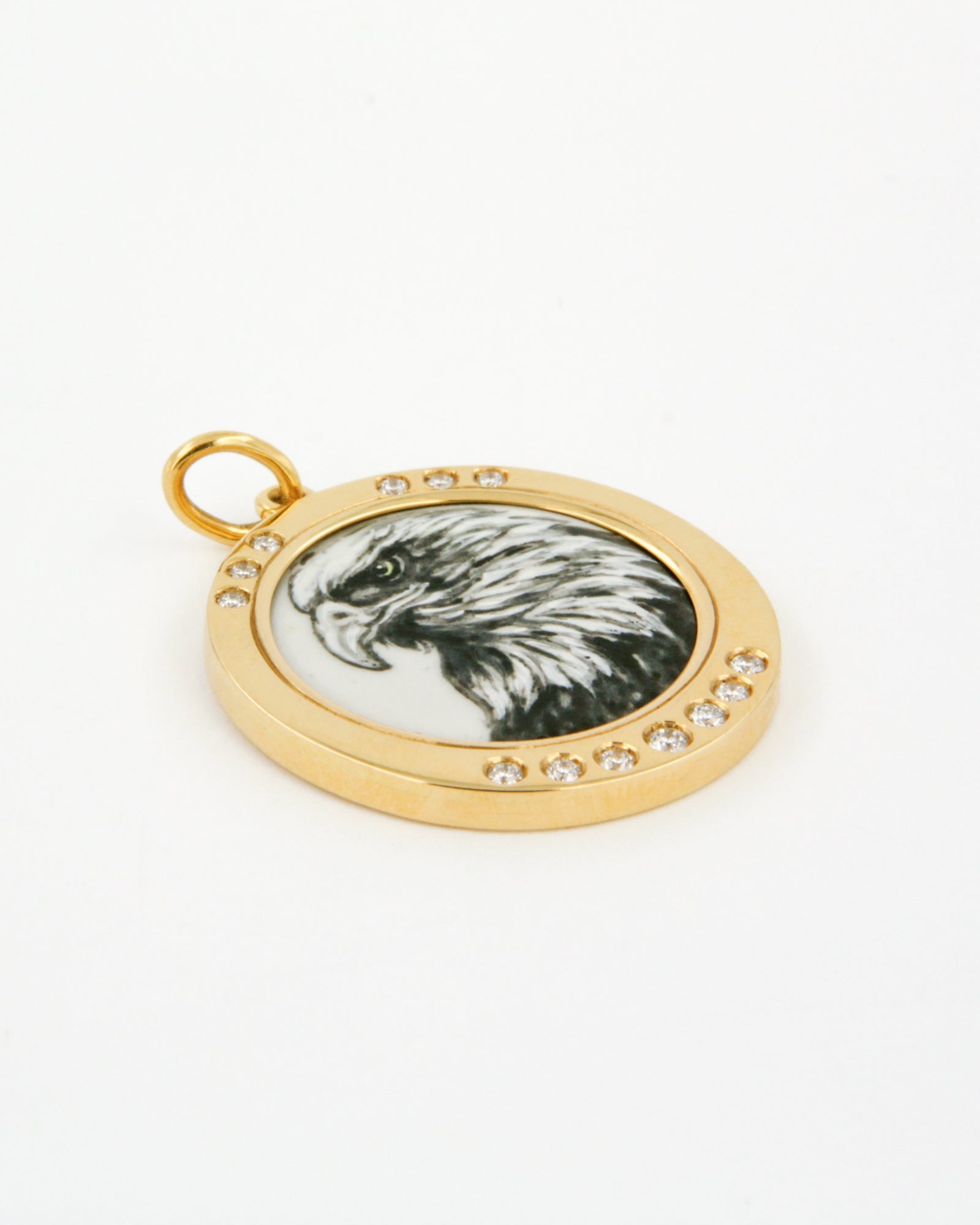 Ciondolo in oro giallo 18K con aquila in smalto a fuoco dipinta a mano e cornice di diamanti bianchi su sfondo blu.