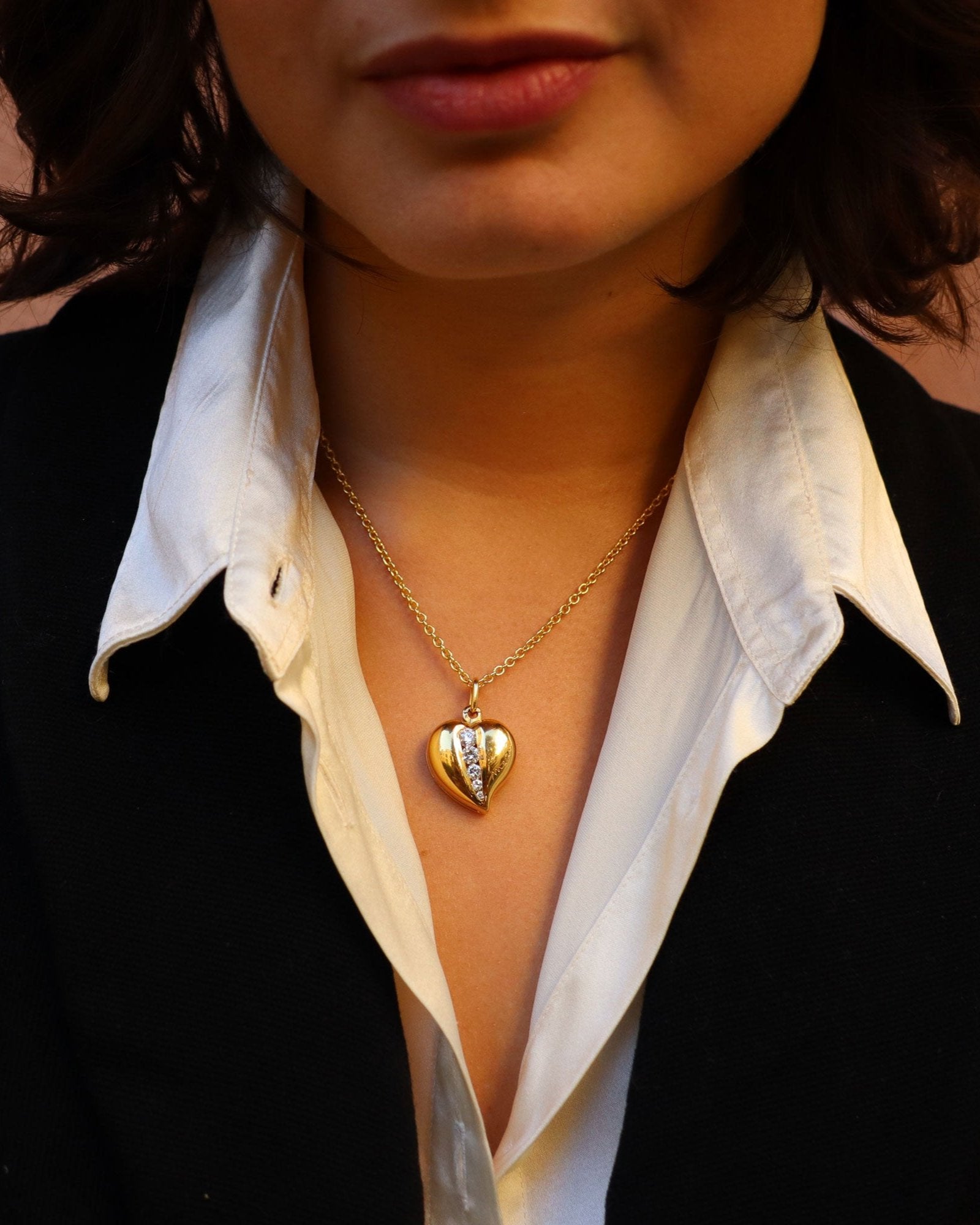 Ciondolo in oro giallo 18 carati a forma di cuore con diamanti bianchi di diverse dimensioni.