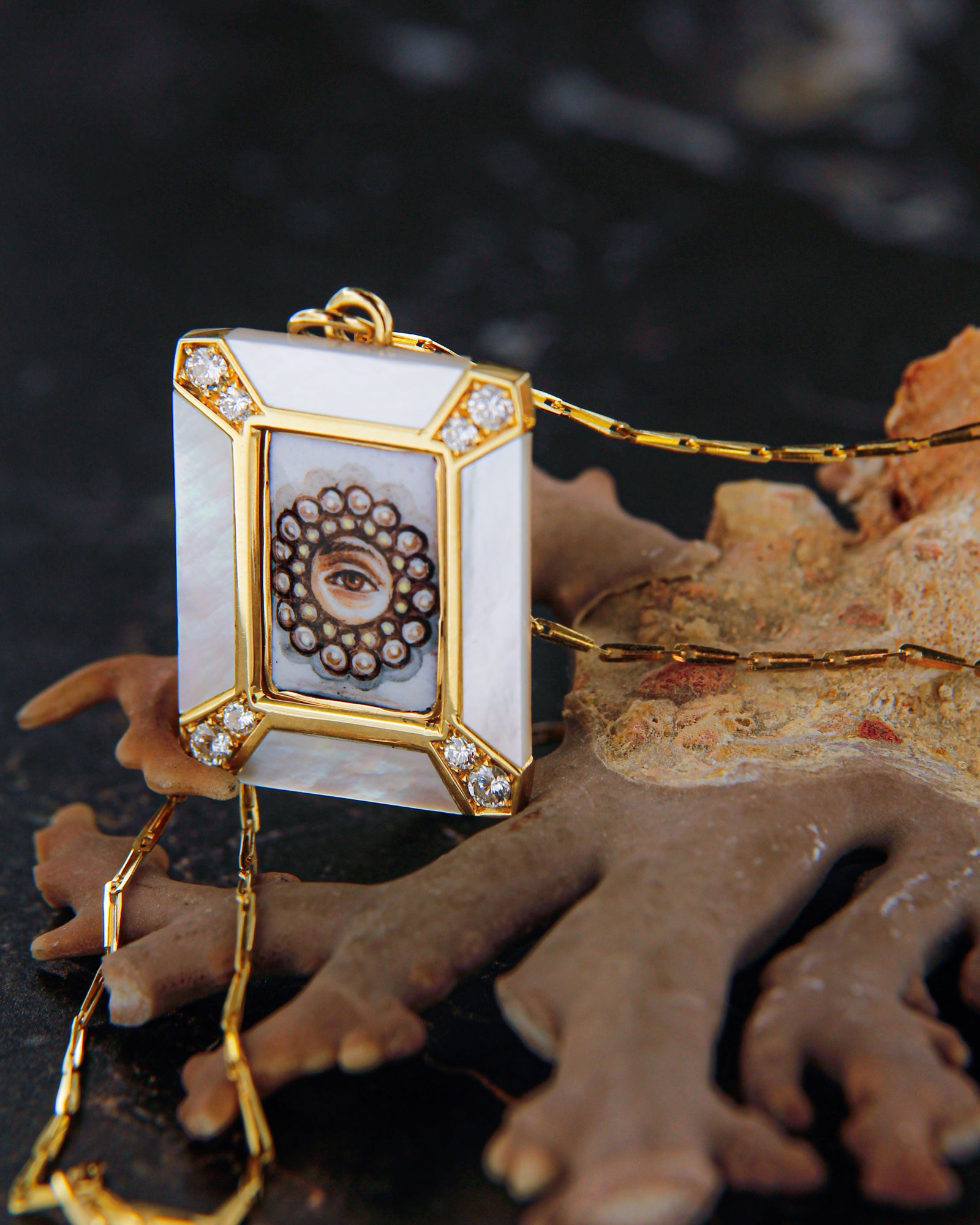 Ciondolo in oro giallo 18 carati con lover’s eye in smalto a fuoco dipinto a mano, su madreperla e impreziosito da diamanti bianchi.