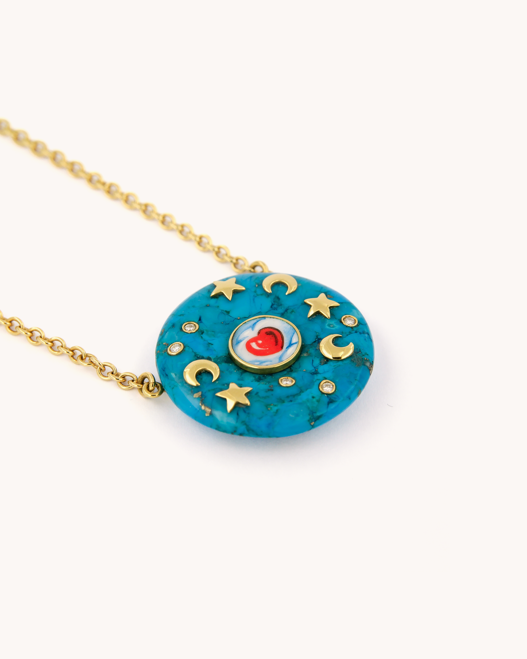 Collana in oro giallo 18 carati con rondella in turchese decorata da lune e stelle dorate in smalto dipinto a mano e diamanti bianchi.