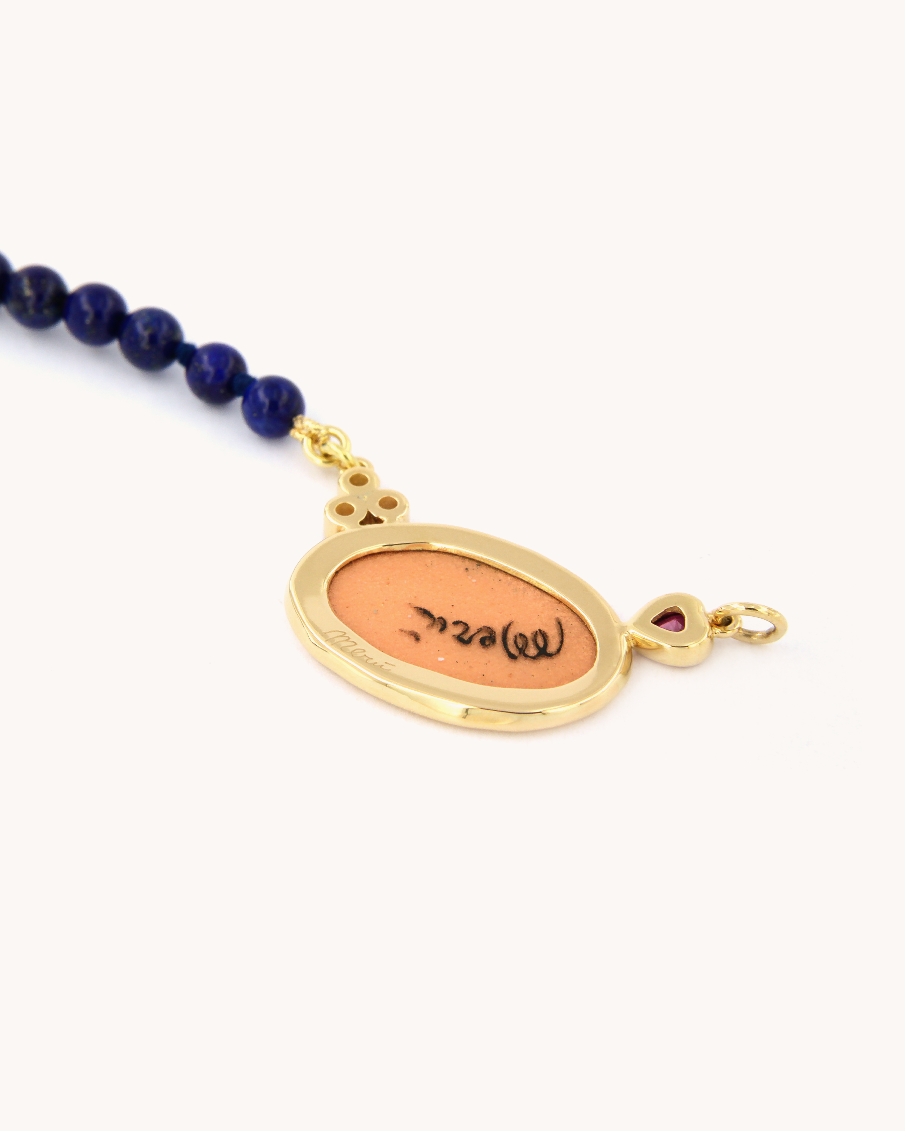 Collana Coloris in lapislazzuli con piastra in smalto a fuoco raffigurante la mano "Sono Qui per Te", rubino a cuore, diamanti e oro giallo 18K.