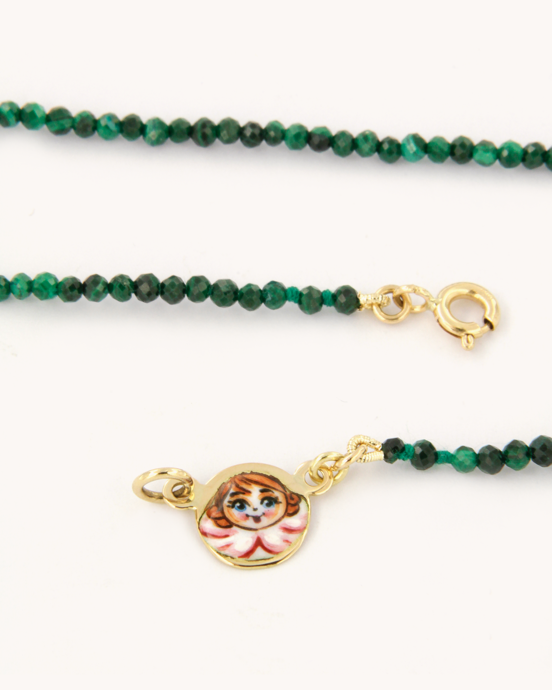 Collana in malachite con piastrina in oro giallo 18 carati decorata con angelo in smalto a fuoco dipinto a mano. Un gioiello firmato Merù Gioielli.