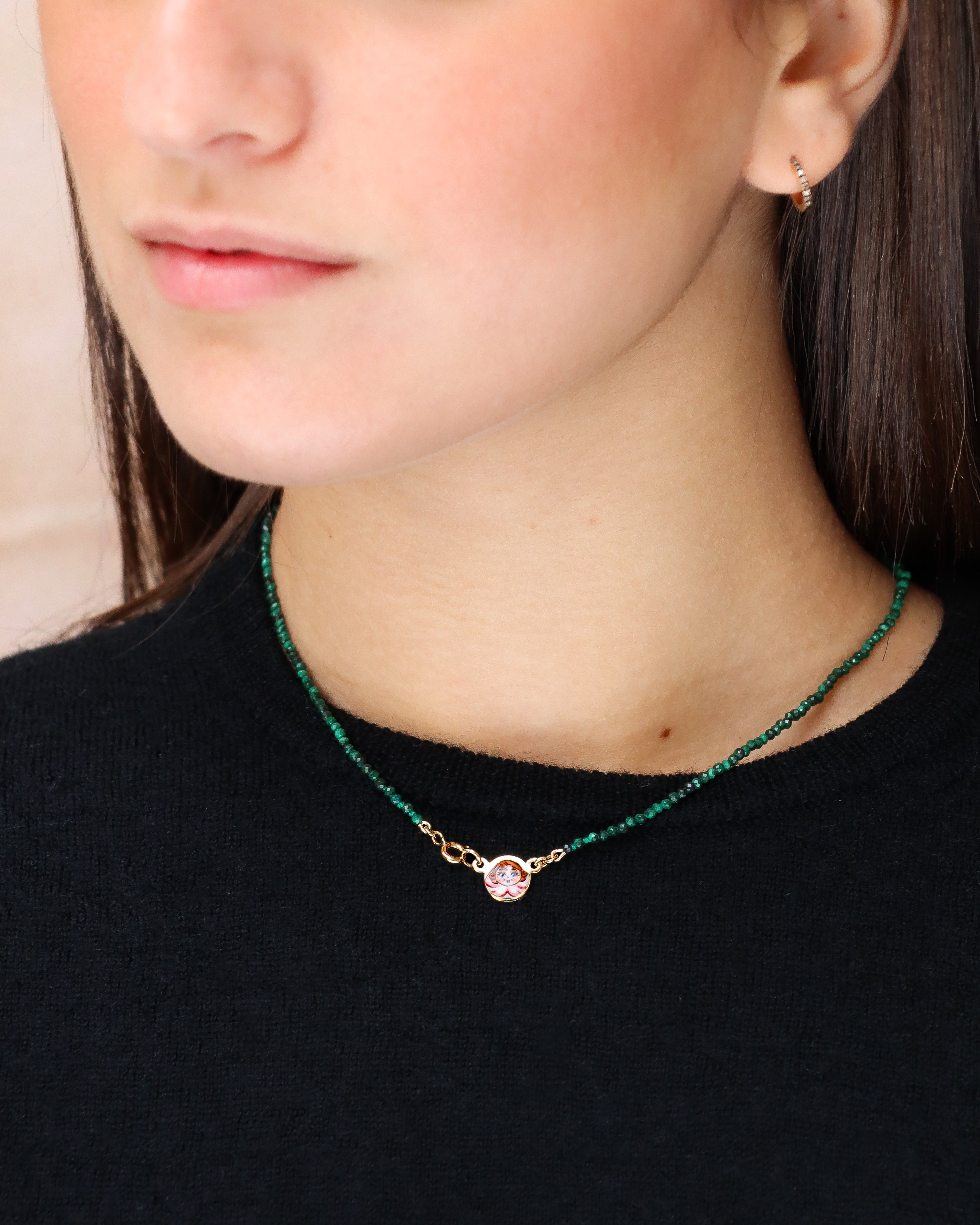 Collana in malachite con piastrina in oro giallo 18 carati decorata con angelo in smalto a fuoco dipinto a mano. Un gioiello firmato Merù Gioielli.