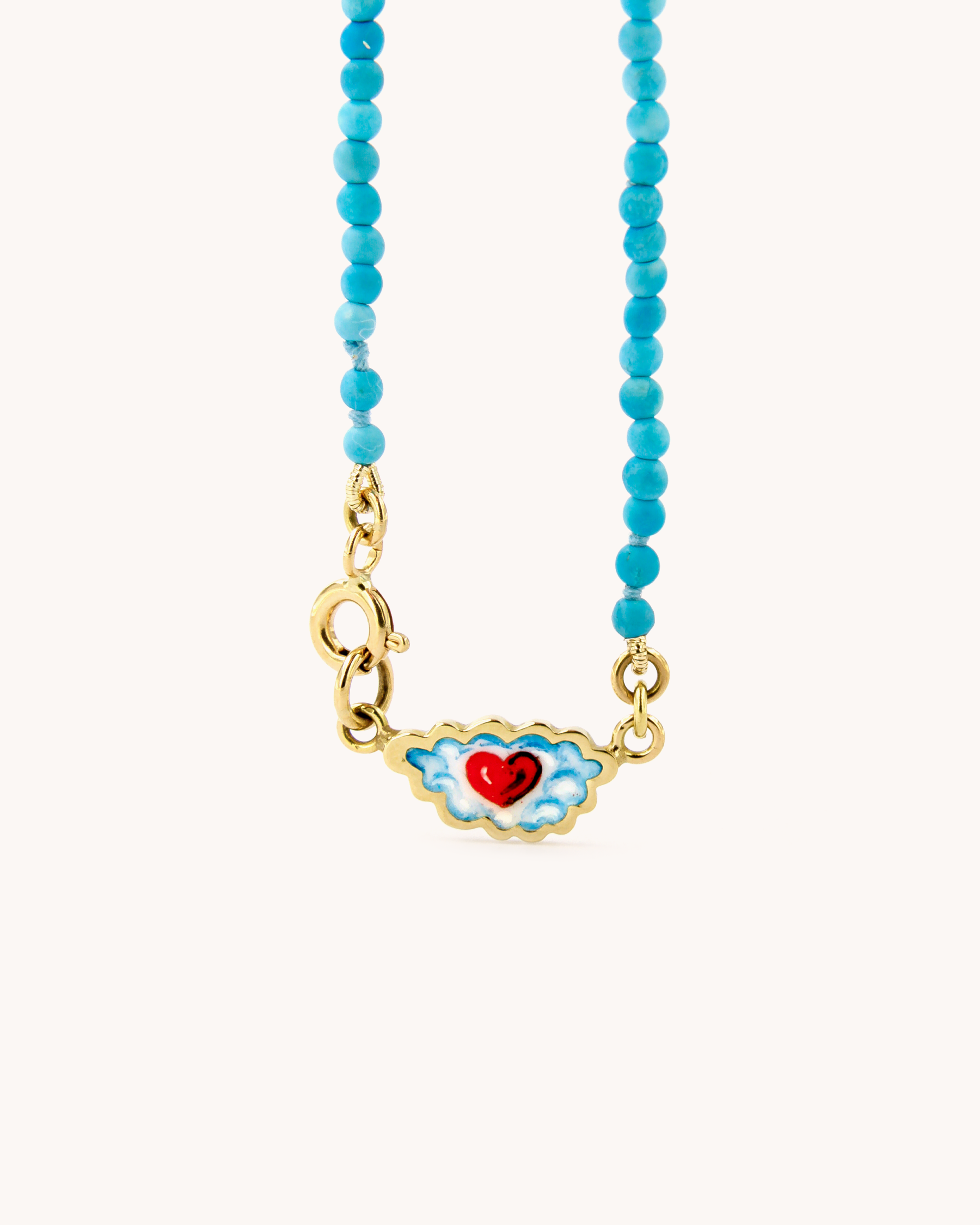 Dettaglio della Collana Coloris con perline di pasta di turchese, chiusura in oro giallo 18 carati e cuore tra le nuvole dipinto a mano in smalto a fuoco.