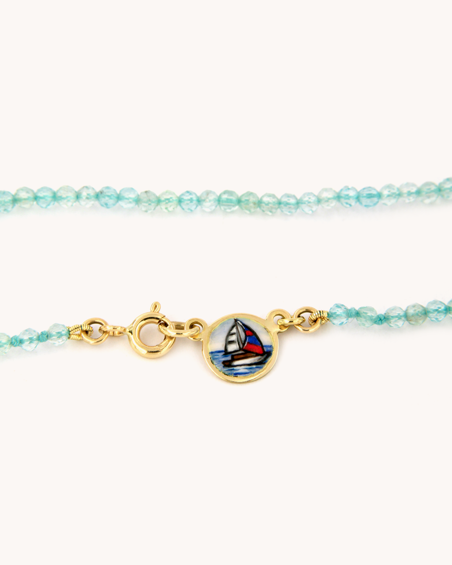 Dettaglio della Collana Coloris Vela con perline sfaccettate di apatite e piastrina in oro giallo 18 carati dipinta a mano in smalto a fuoco