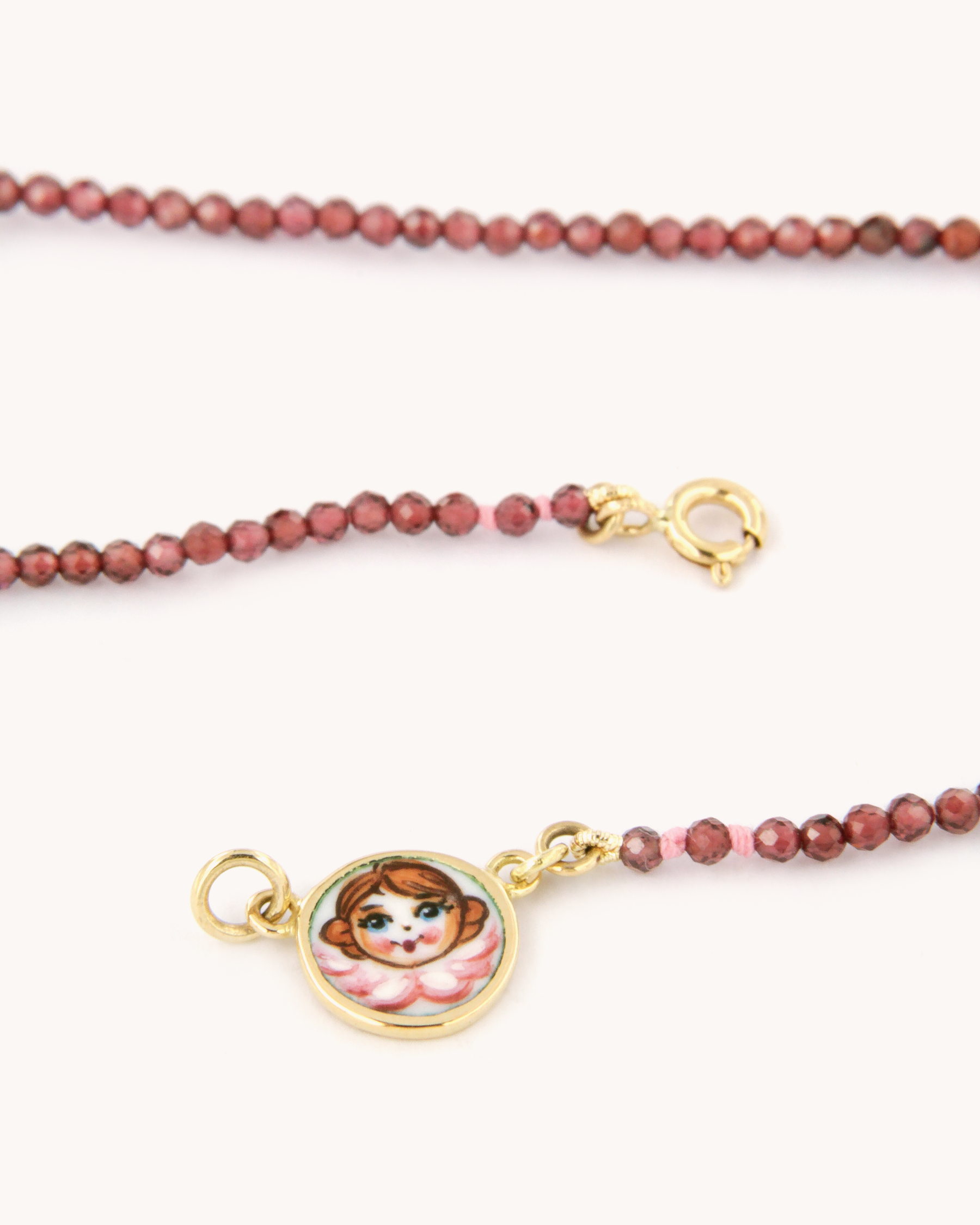 Collana con perline di granato e piastrina in oro 18 carati decorata con angelo in smalto a fuoco dipinto a mano – Merù Gioielli