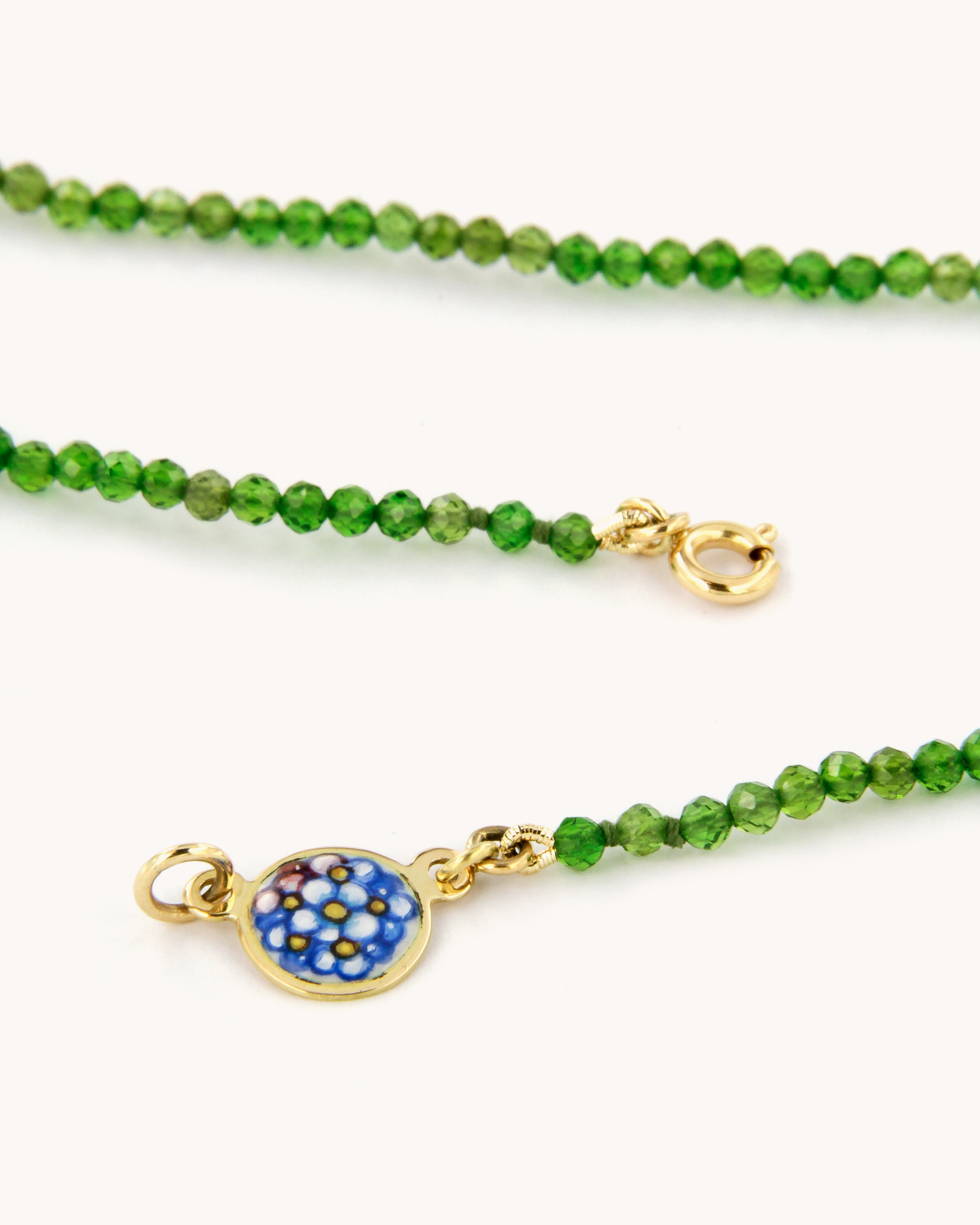 Collana in cromo diopside con piastrina in oro giallo 18 carati decorata con fiori “non ti scordar di me” in smalto a fuoco dipinto a mano.