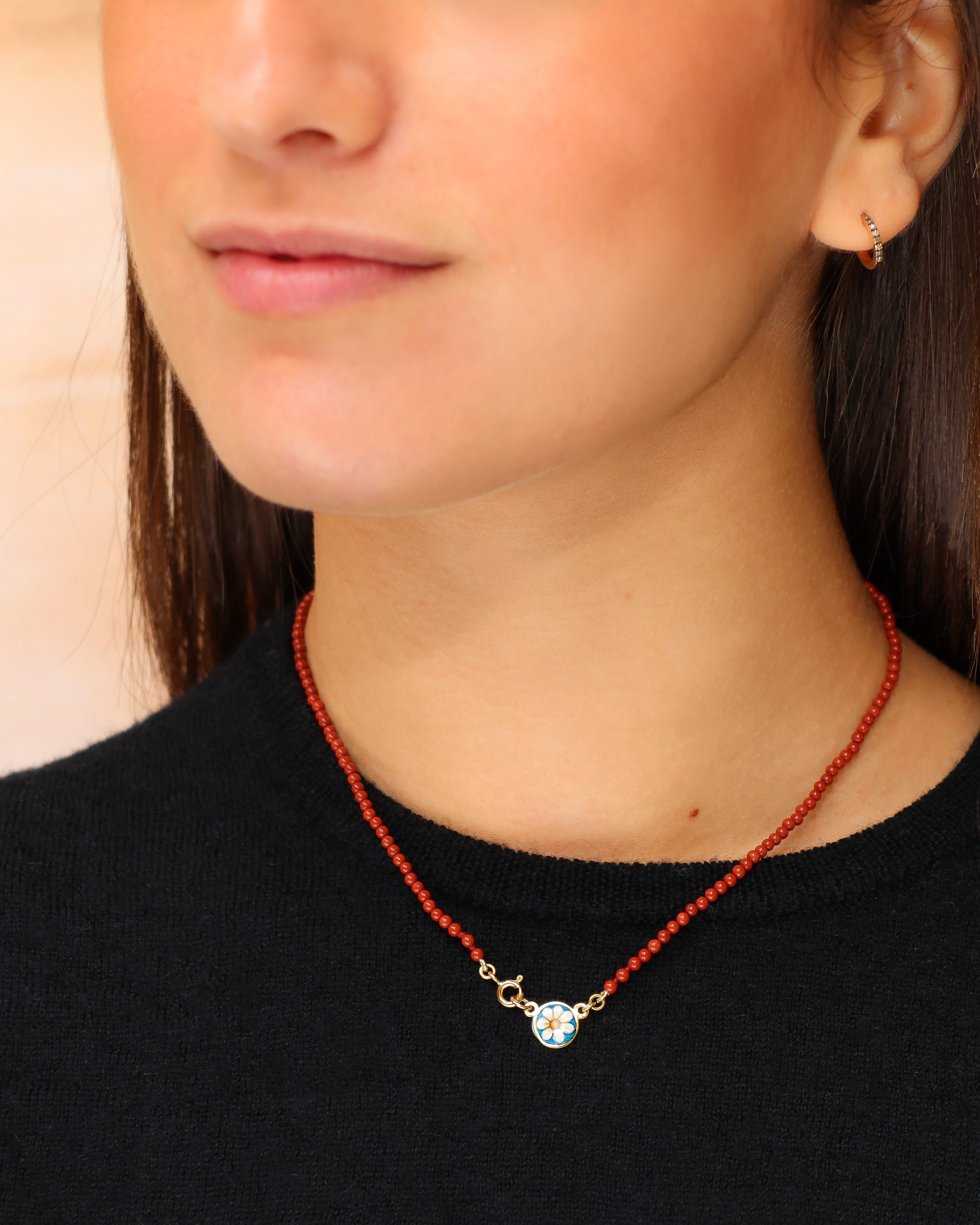 Collana con perle di diaspro rosso e piastrina in oro giallo 18K decorata con margherita in smalto a fuoco dipinto a mano.