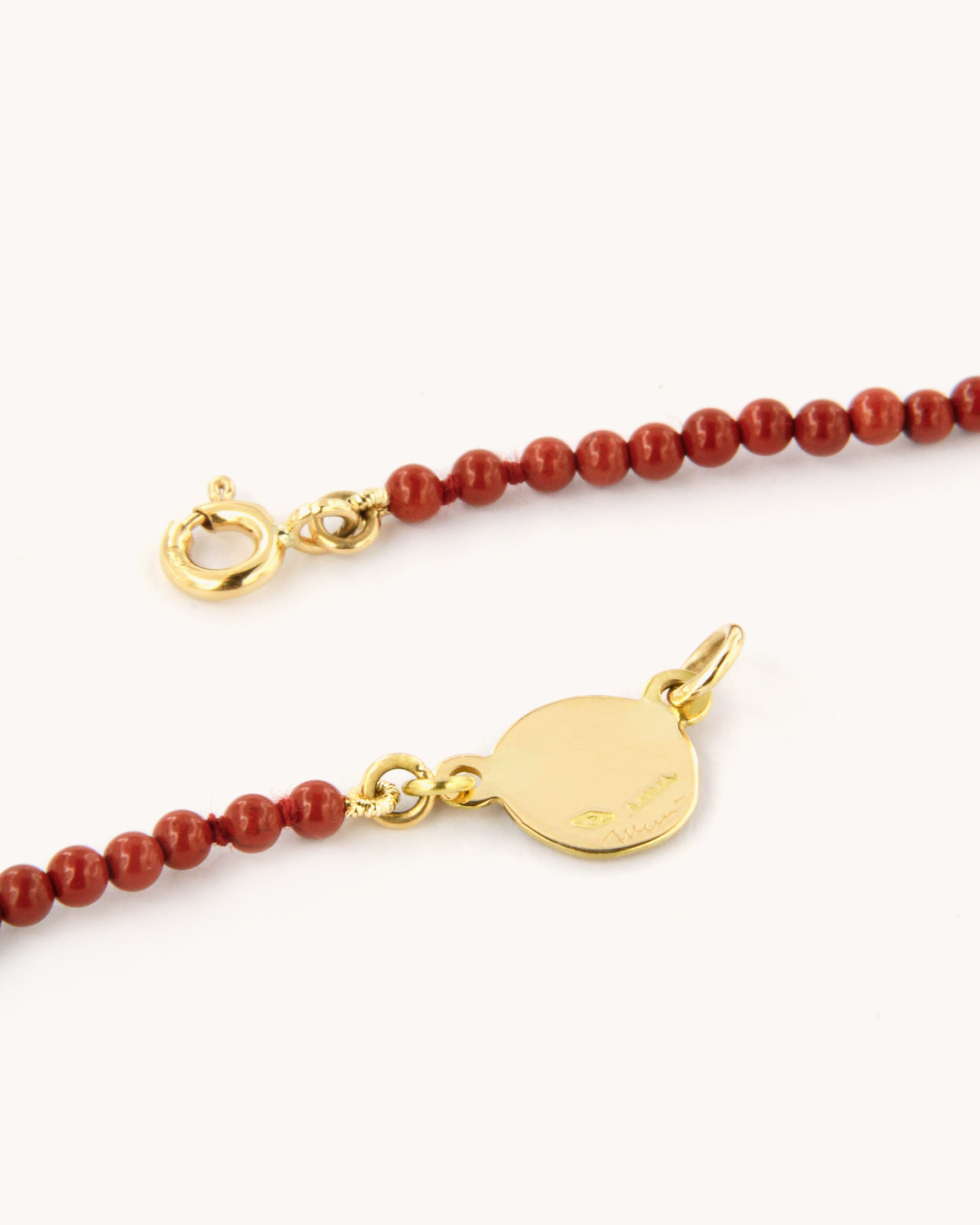 Collana infilata con perle di diaspro rosso e piastrina in oro giallo 18 carati decorata con fiore di pansè in smalto a fuoco dipinto a mano