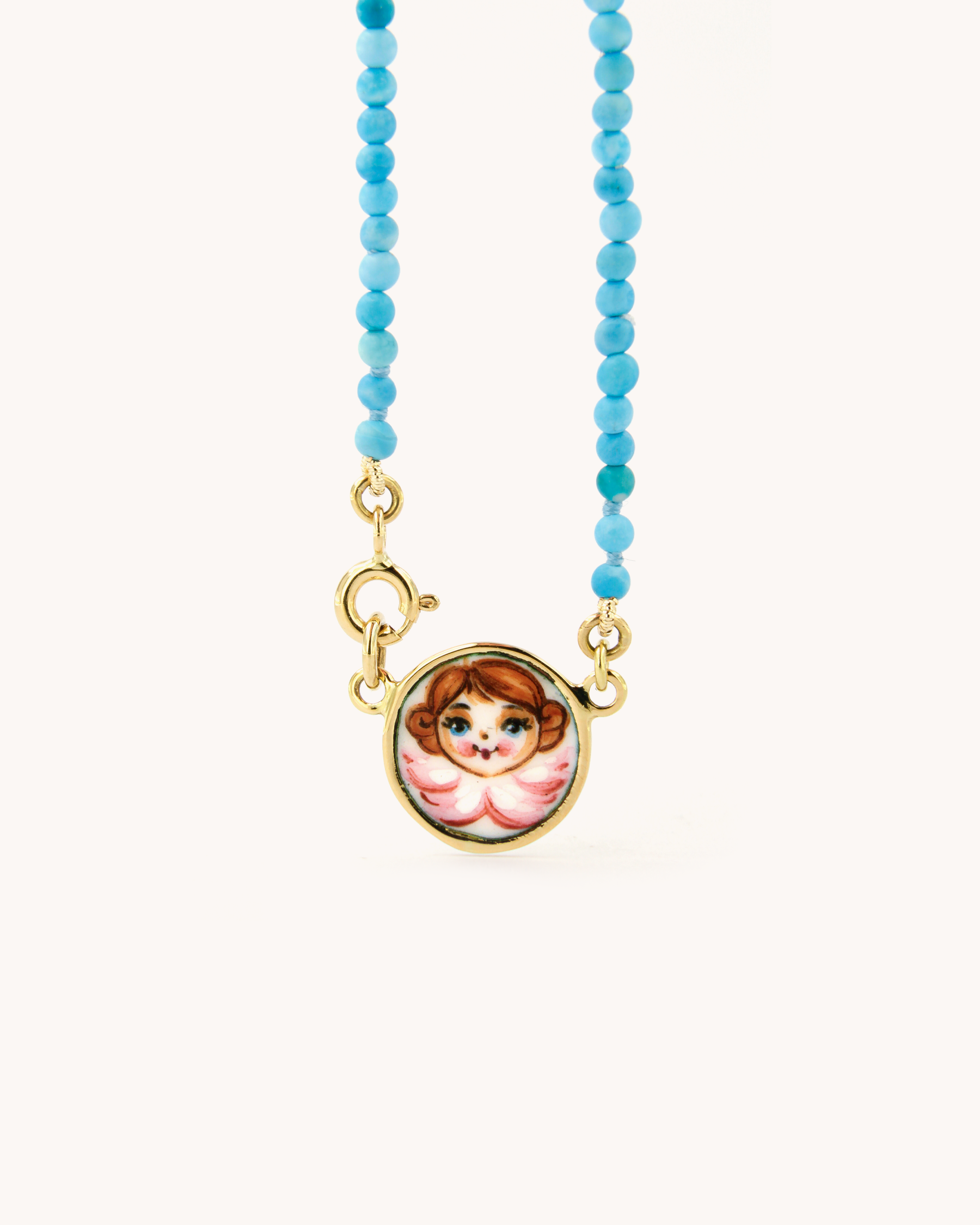 Collana Coloris con perline di pasta di turchese, pendente angelo smaltato a fuoco e chiusura in oro giallo 18 carati