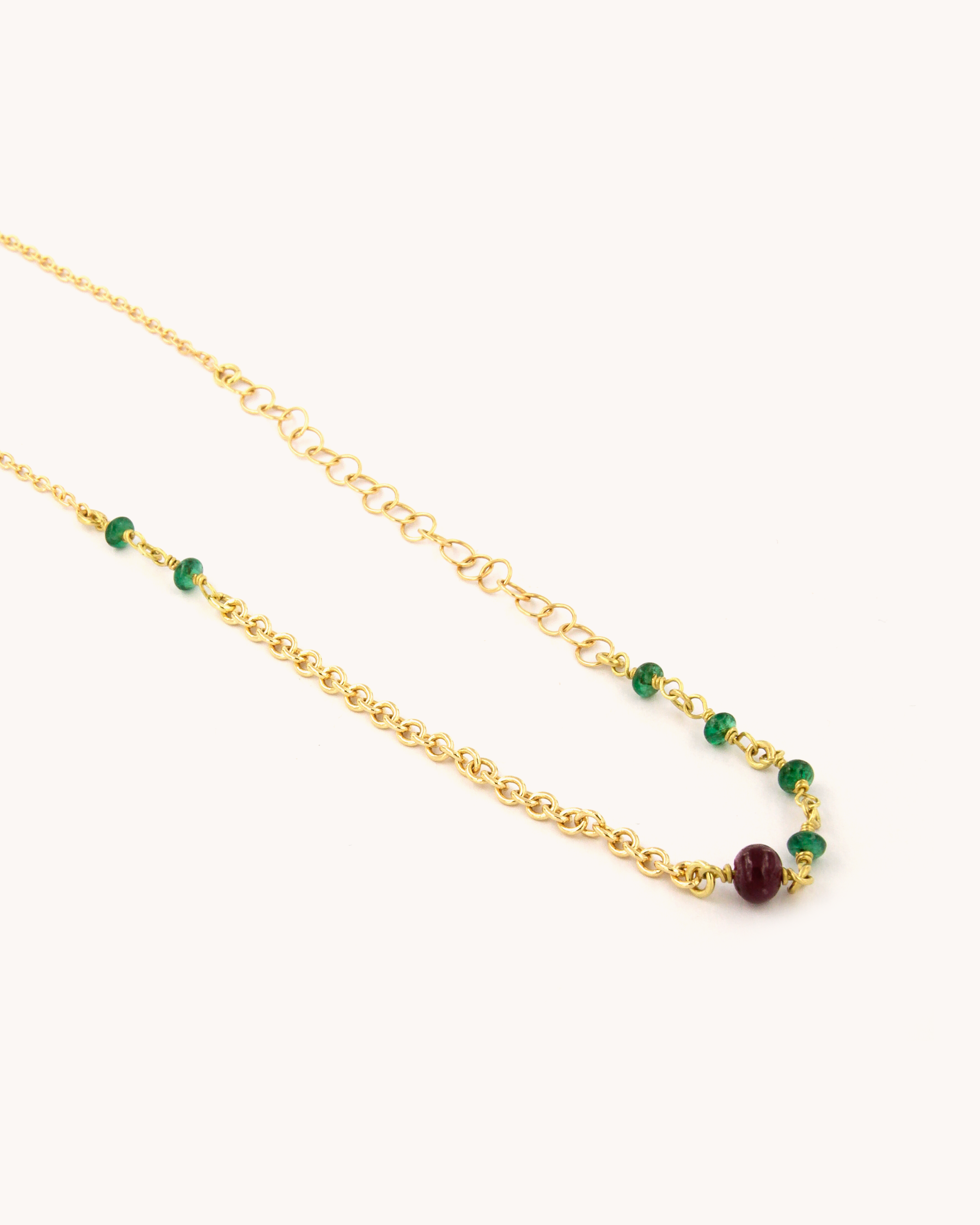 Collana in oro giallo 18K a catena mista con radice di rubino e smeraldi.