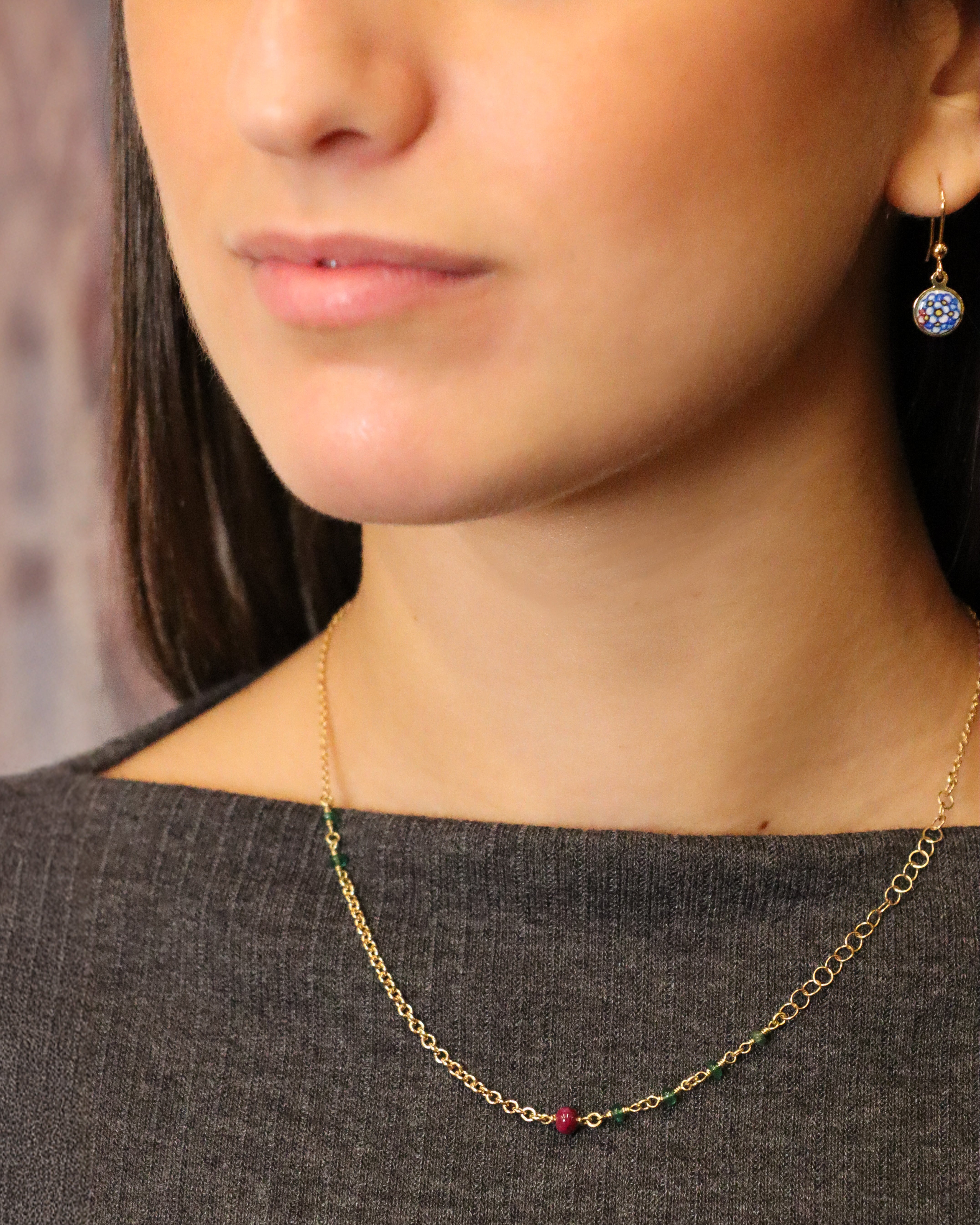 Collana in oro giallo 18K a catena mista con radice di rubino e smeraldi.