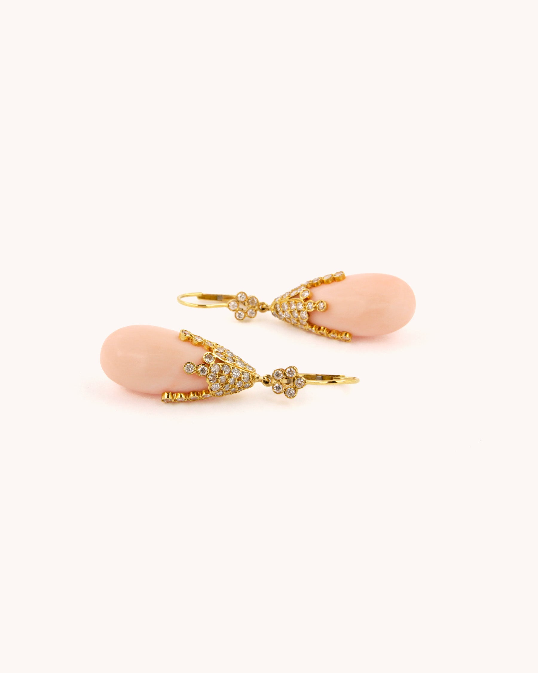 Orecchini pendenti in oro giallo 18K con corallo rosa naturale a goccia e diamanti incastonati a cascata.