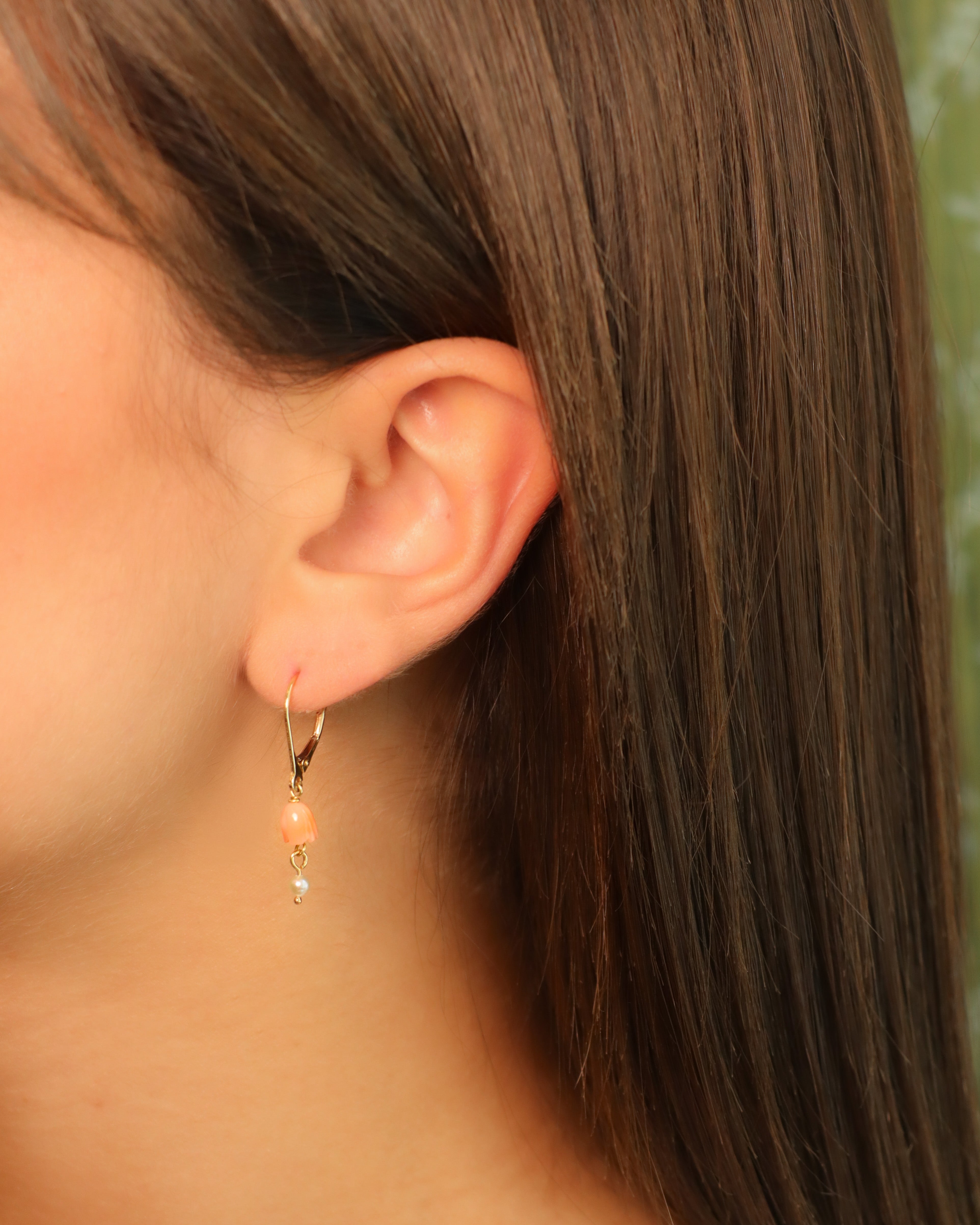 Orecchini pendenti in oro giallo 18K con fiore in corallo rosa e perla bianca pendente.