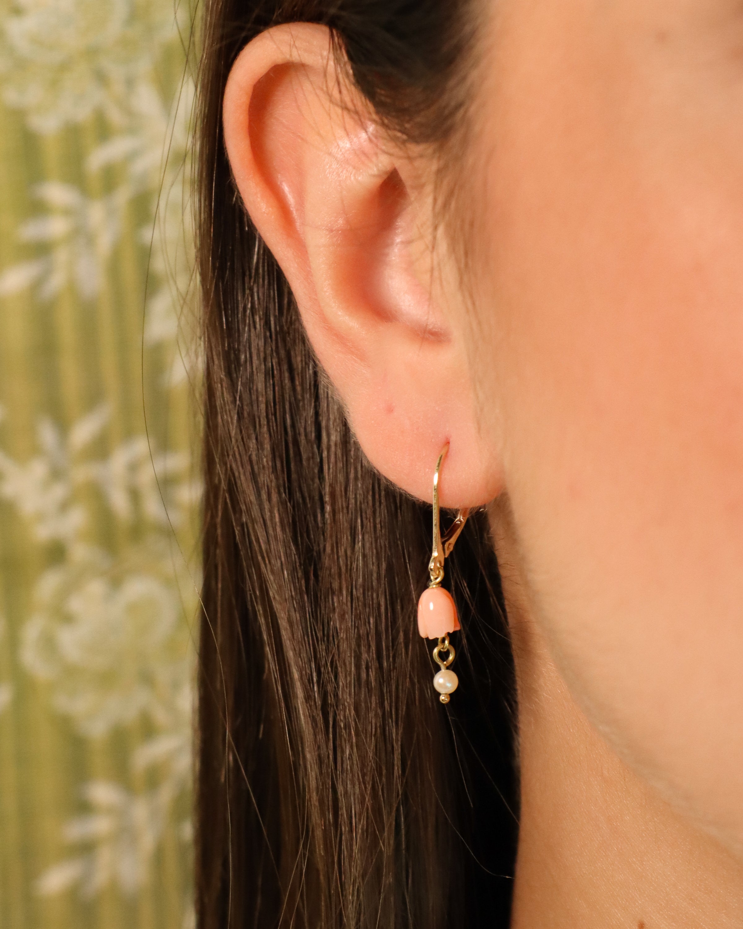 Orecchini pendenti in oro giallo 18K con fiore in corallo rosa e perla bianca pendente.