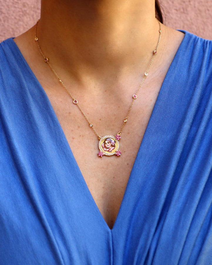 Collana Angelo Rosa in oro giallo 18 carati con pendente circolare in smalto figurativo dipinto a mano, impreziosita da diamanti e zaffiri rosa.