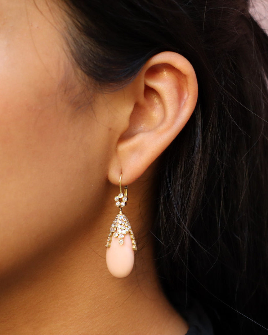 Orecchini pendenti in oro giallo 18K con corallo rosa naturale a goccia e diamanti incastonati a cascata.