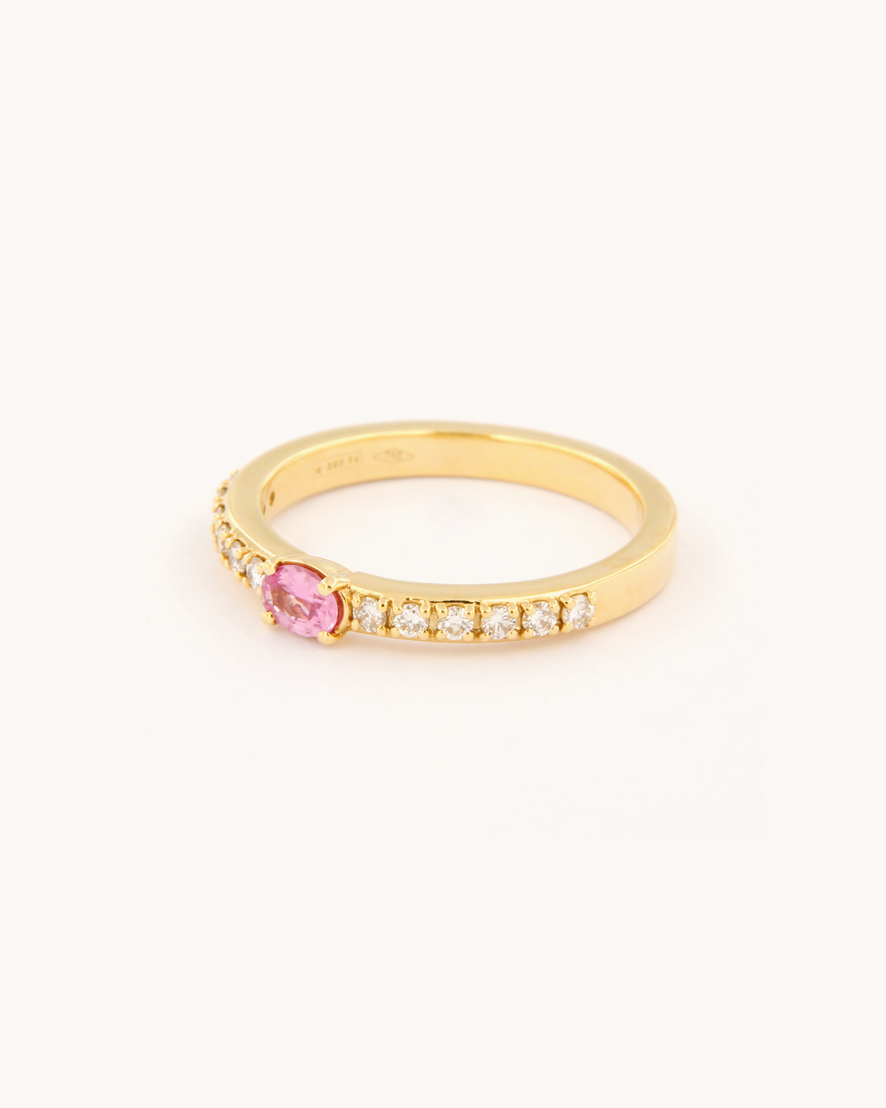 Anello oro 18K con zaffiro rosa ovale centrale e diamanti laterali.
