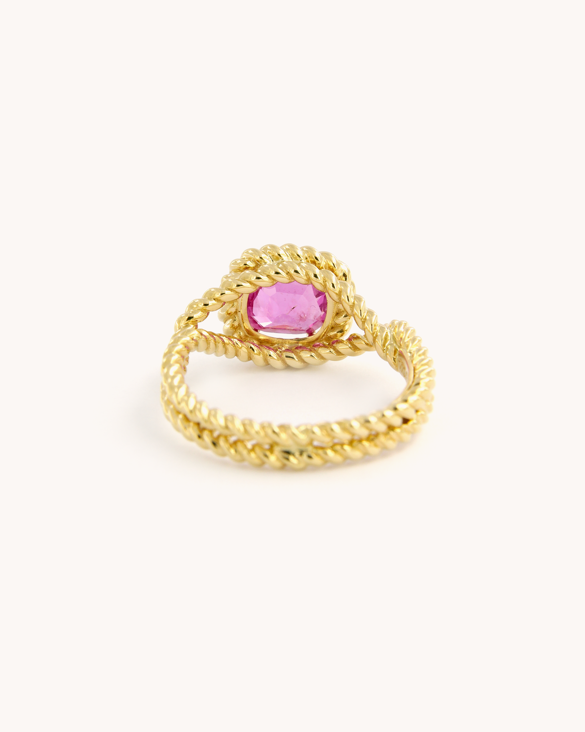Anello Torchon in oro giallo 18 carati con zaffiro rosa naturale, incastonato in una montatura con lavorazione a corda intrecciata.