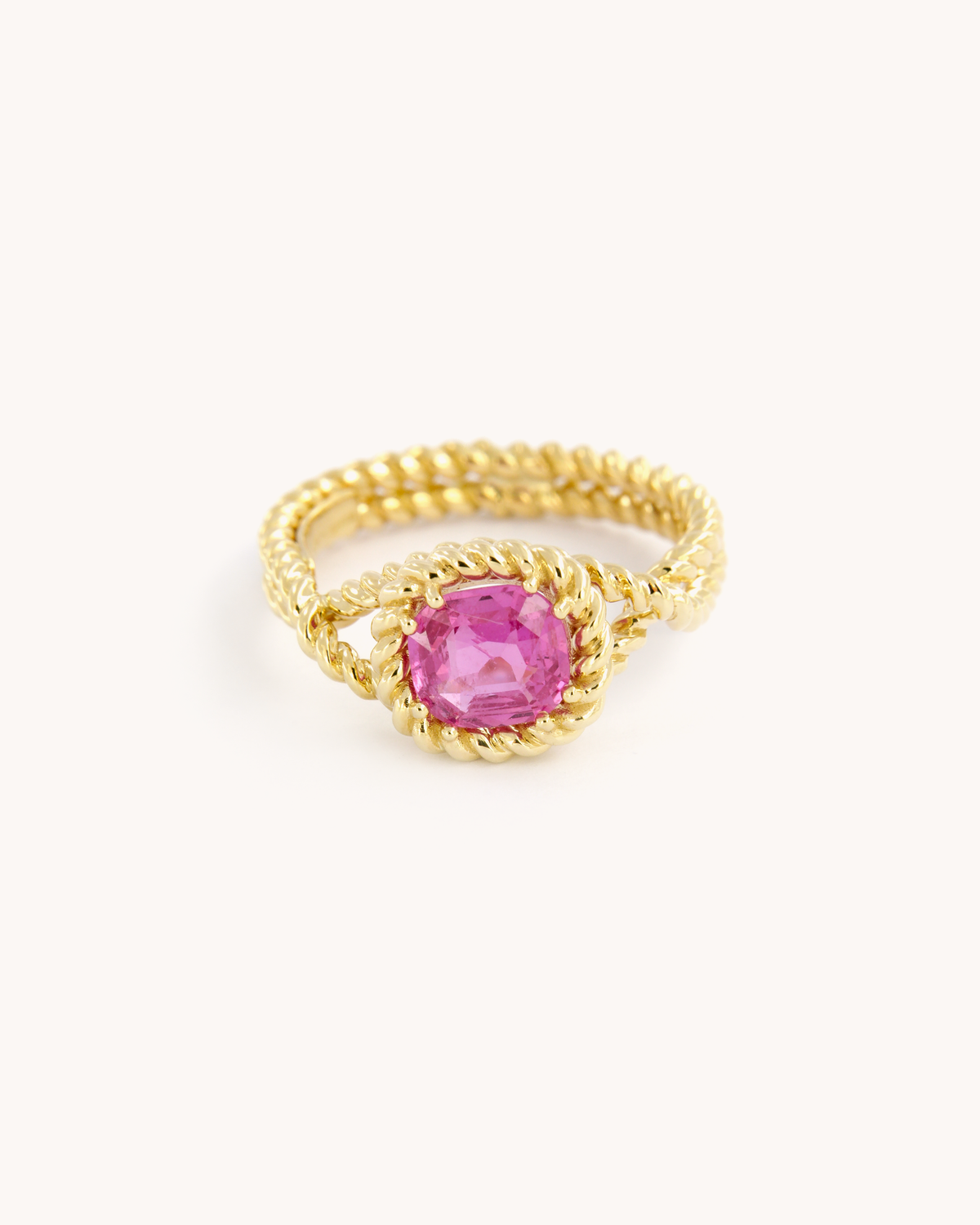 Anello Torchon in oro giallo 18 carati con zaffiro rosa naturale, incastonato in una montatura con lavorazione a corda intrecciata.