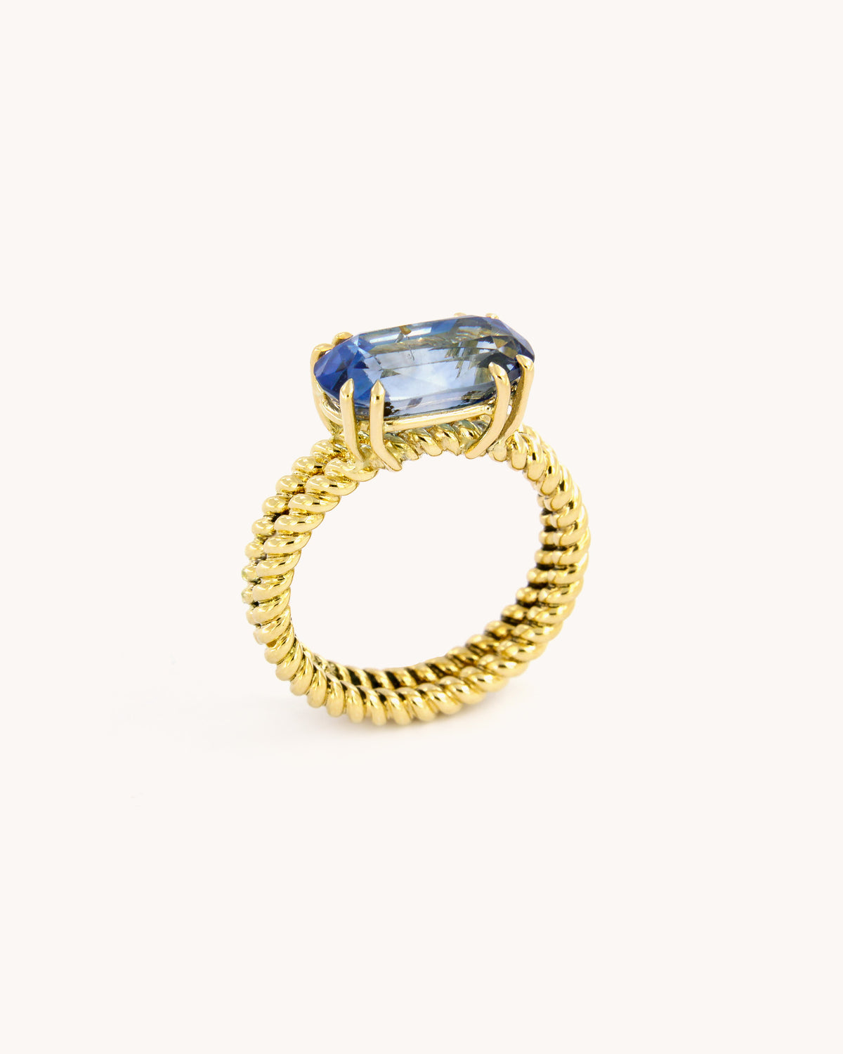 Anello Torchon in oro giallo 18 carati con zaffiro zonato blu dalle variazioni cromatiche naturali, vista frontale.
