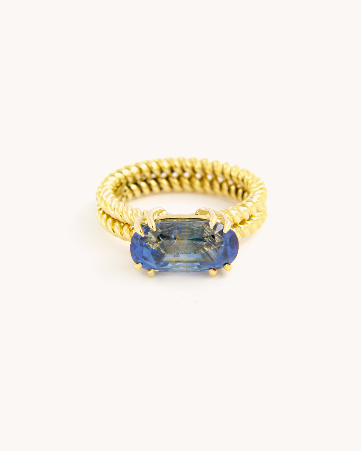 Anello Torchon in oro giallo 18 carati con zaffiro zonato blu dalle variazioni cromatiche naturali, vista frontale.