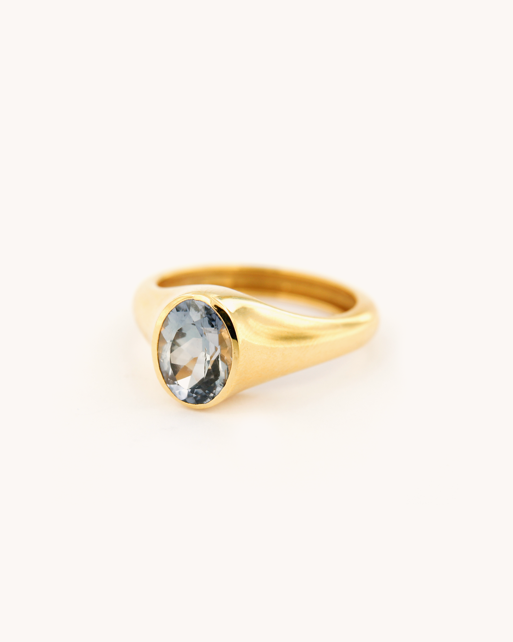 Anello in oro giallo 18 carati con zaffiro blu chiaro ovale, design essenziale firmato Merù Gioielli.
