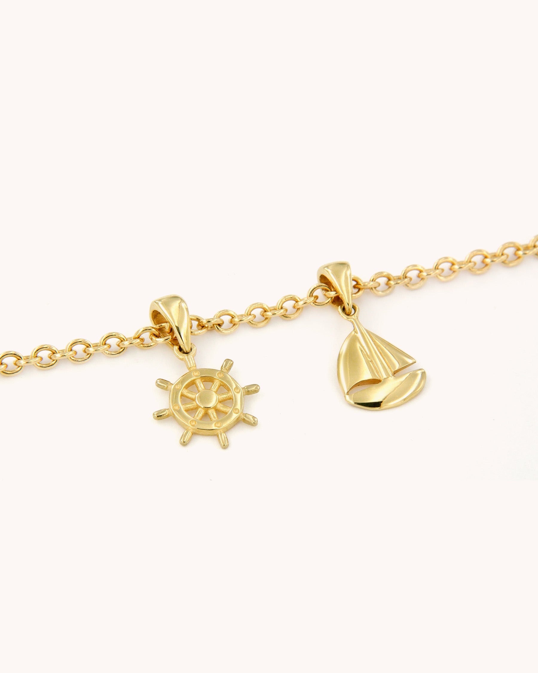 Bracciale Avventura Oceanica in oro giallo 18 carati con charm a forma di barca e timone
