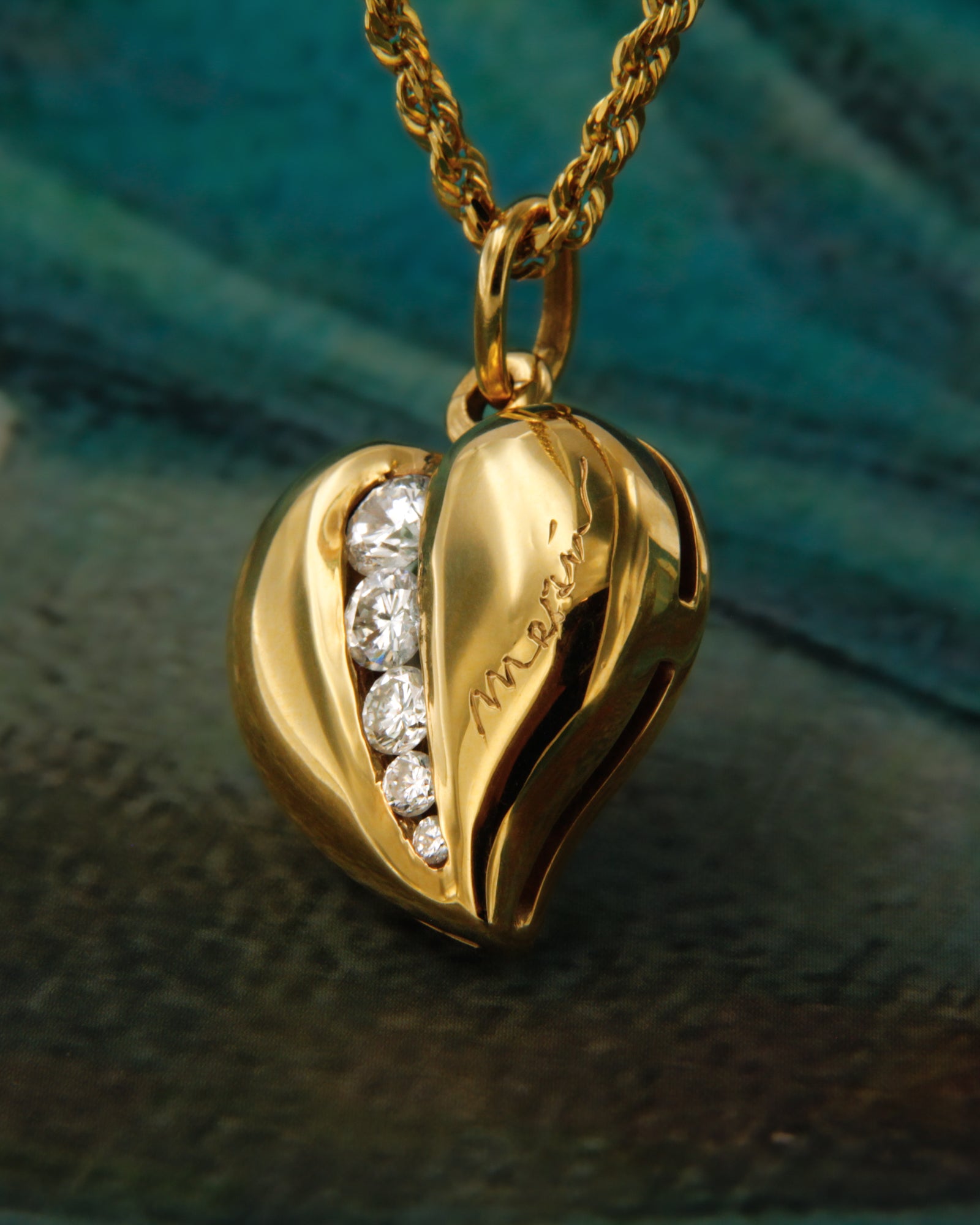 Ciondolo in oro giallo 18 carati a forma di cuore con diamanti bianchi di diverse dimensioni.