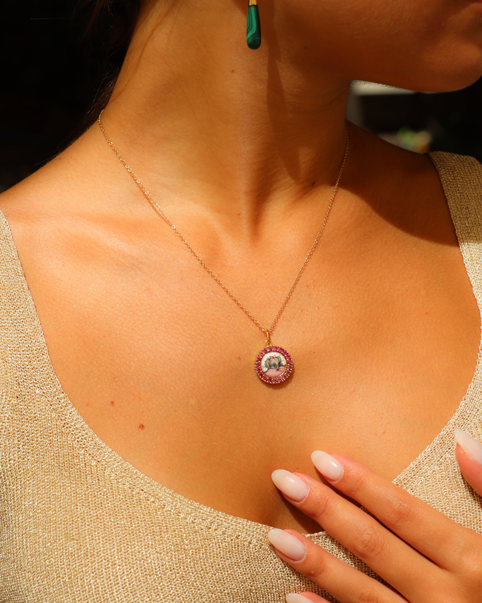 Ciondolo in oro giallo 18K con elefantino in smalto a fuoco dipinto a mano e cornice di zaffiri rosa.