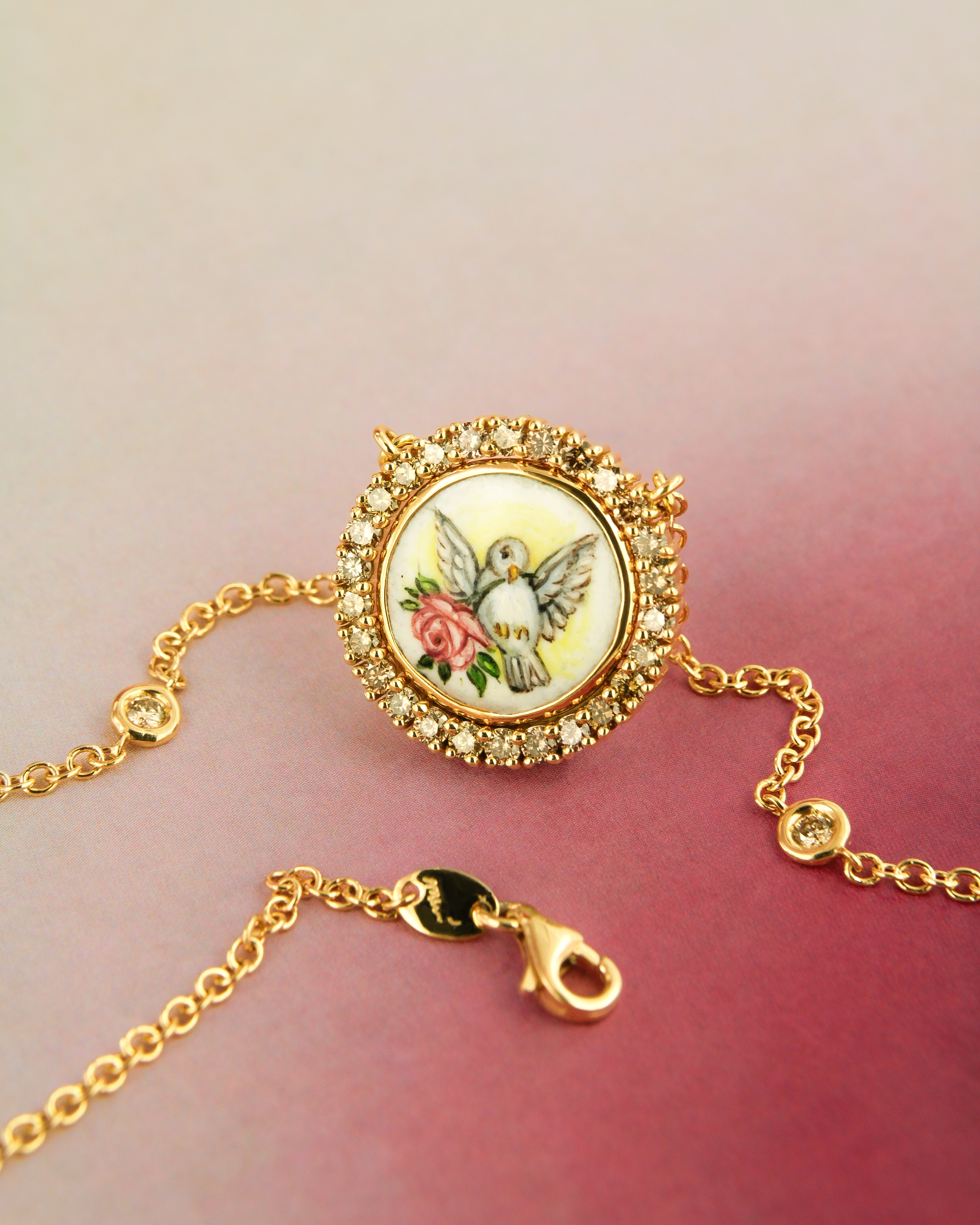 Collana in oro giallo 18 carati con pendente raffigurante una colomba con rosa, dipinta a mano in smalto a fuoco e circondata da diamanti brown.