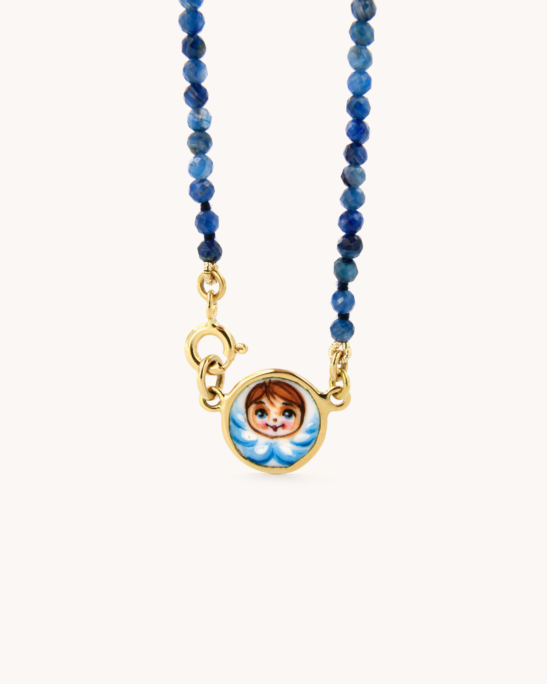 Collana Coloris con perline di cianite, chiusura in oro giallo 18 carati e pendente angelo smaltato a mano.