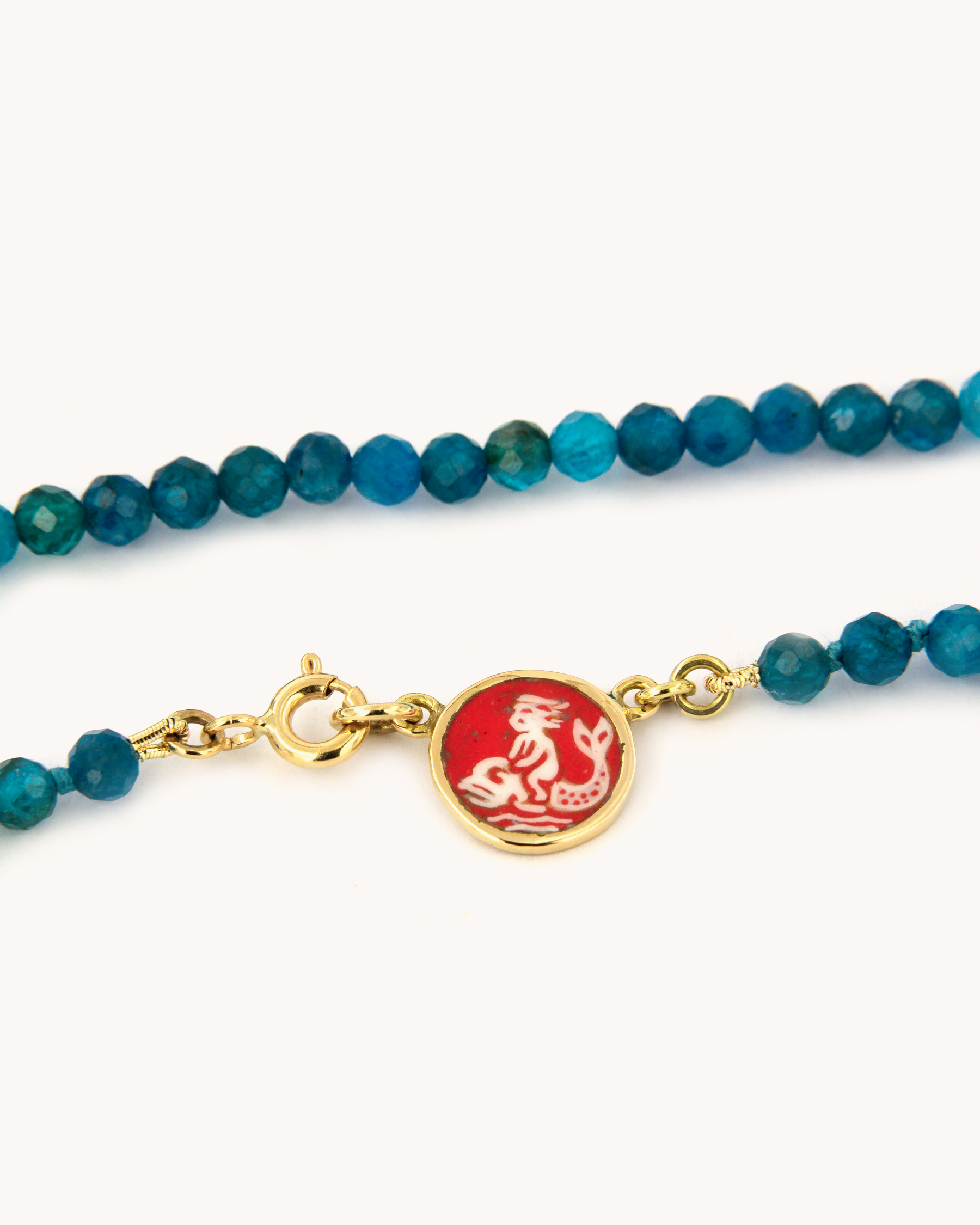 Collana Coloris con perle sfaccettate di apatite scura e piastrina Ninfa Marina dipinta a mano in smalto a fuoco su oro giallo 18 carati.
