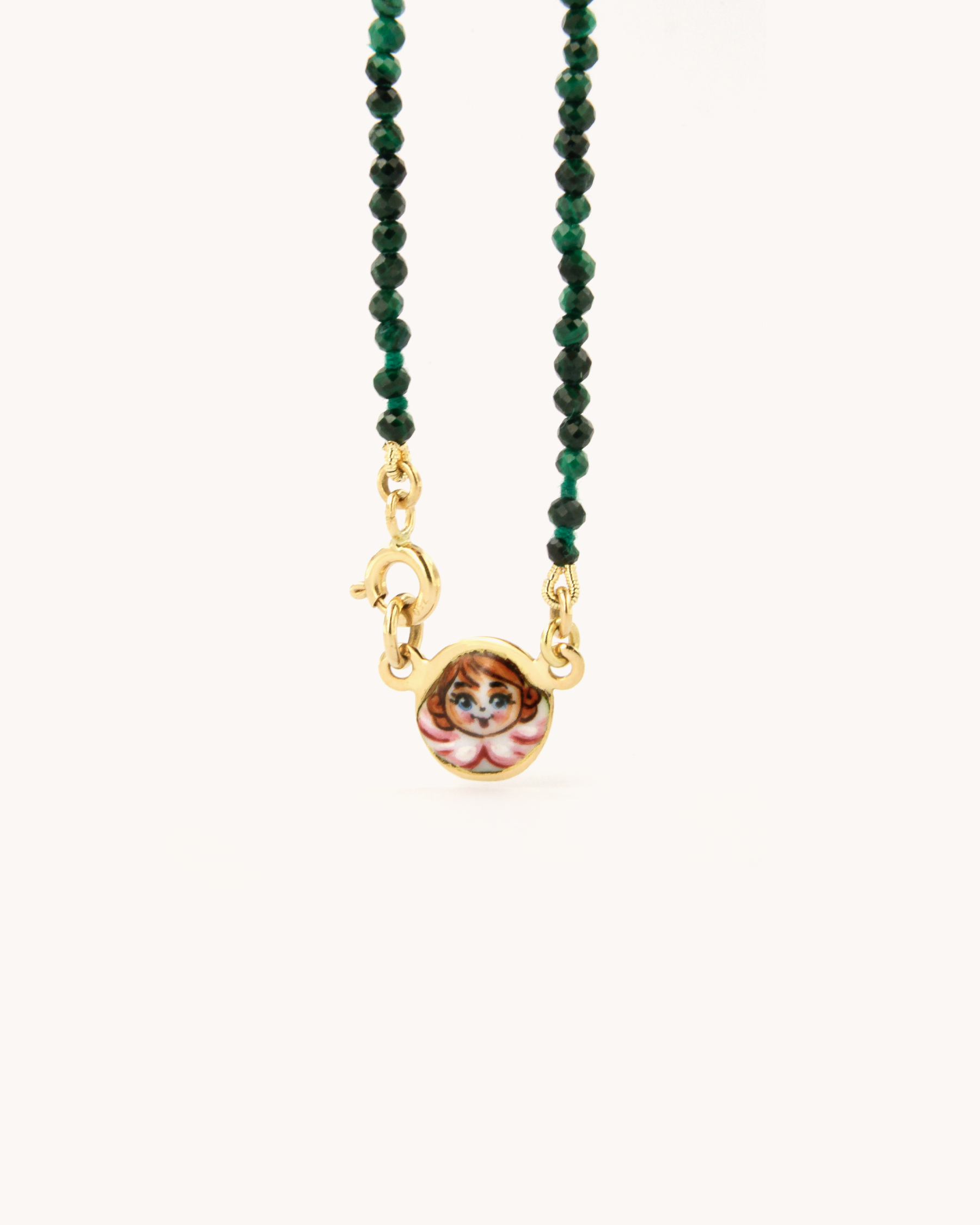 Collana in malachite con piastrina in oro giallo 18 carati decorata con angelo in smalto a fuoco dipinto a mano. Un gioiello firmato Merù Gioielli.