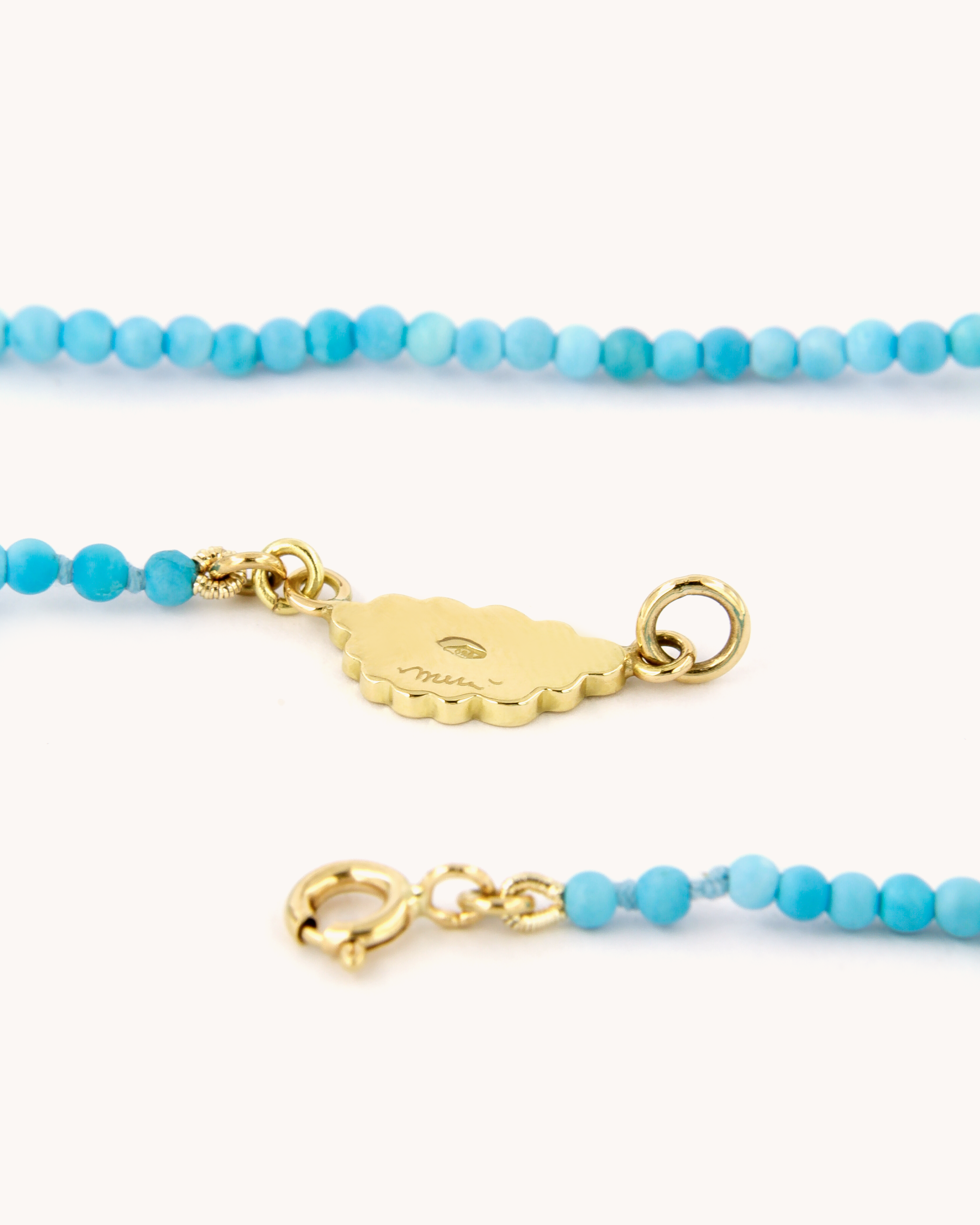 Dettaglio della Collana Coloris con perline di pasta di turchese, chiusura in oro giallo 18 carati e cuore tra le nuvole dipinto a mano in smalto a fuoco.