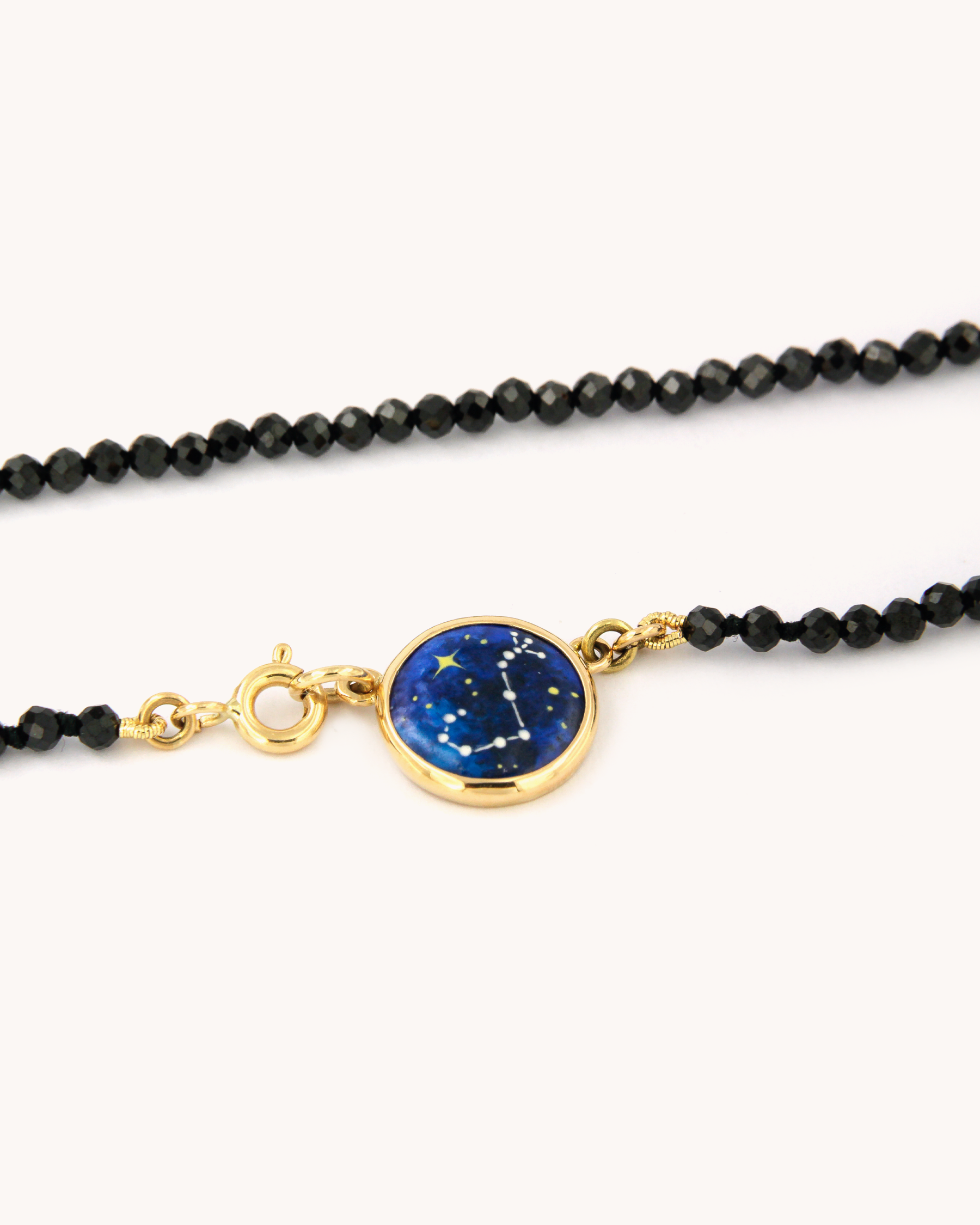 Collana Coloris Scorpione con perline sfaccettate di spinello nero e piastrina in oro giallo 18 carati dipinta a mano in smalto a fuoco.