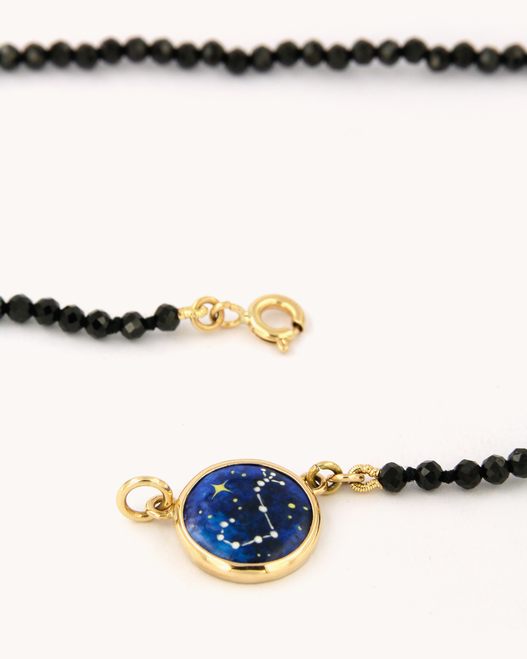 Collana Coloris Scorpione con perline sfaccettate di spinello nero e piastrina in oro giallo 18 carati dipinta a mano in smalto a fuoco.