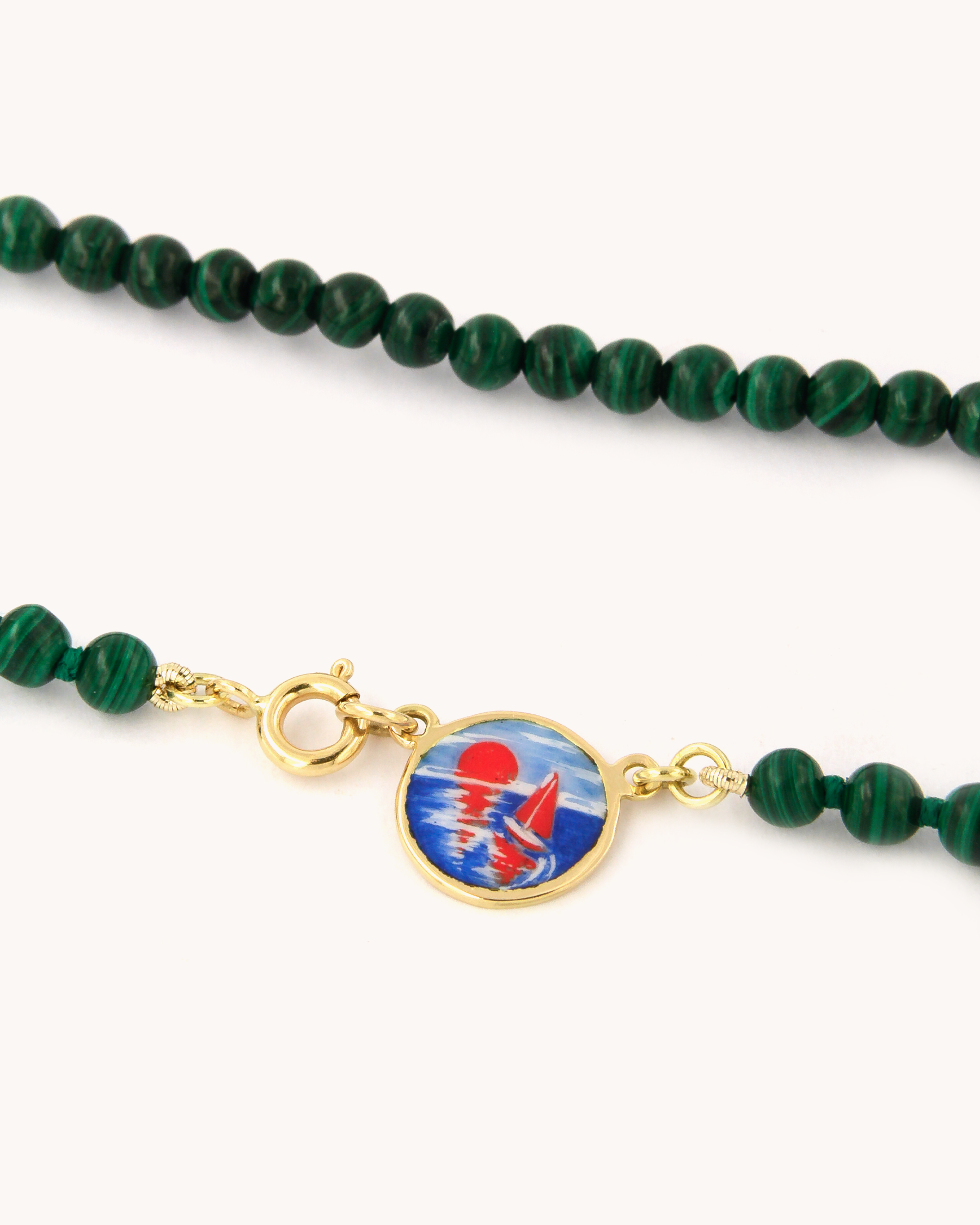 Dettaglio della Collana Coloris Tramonto in malachite, con piastra in oro giallo 18K e smalto a fuoco dipinto a mano.