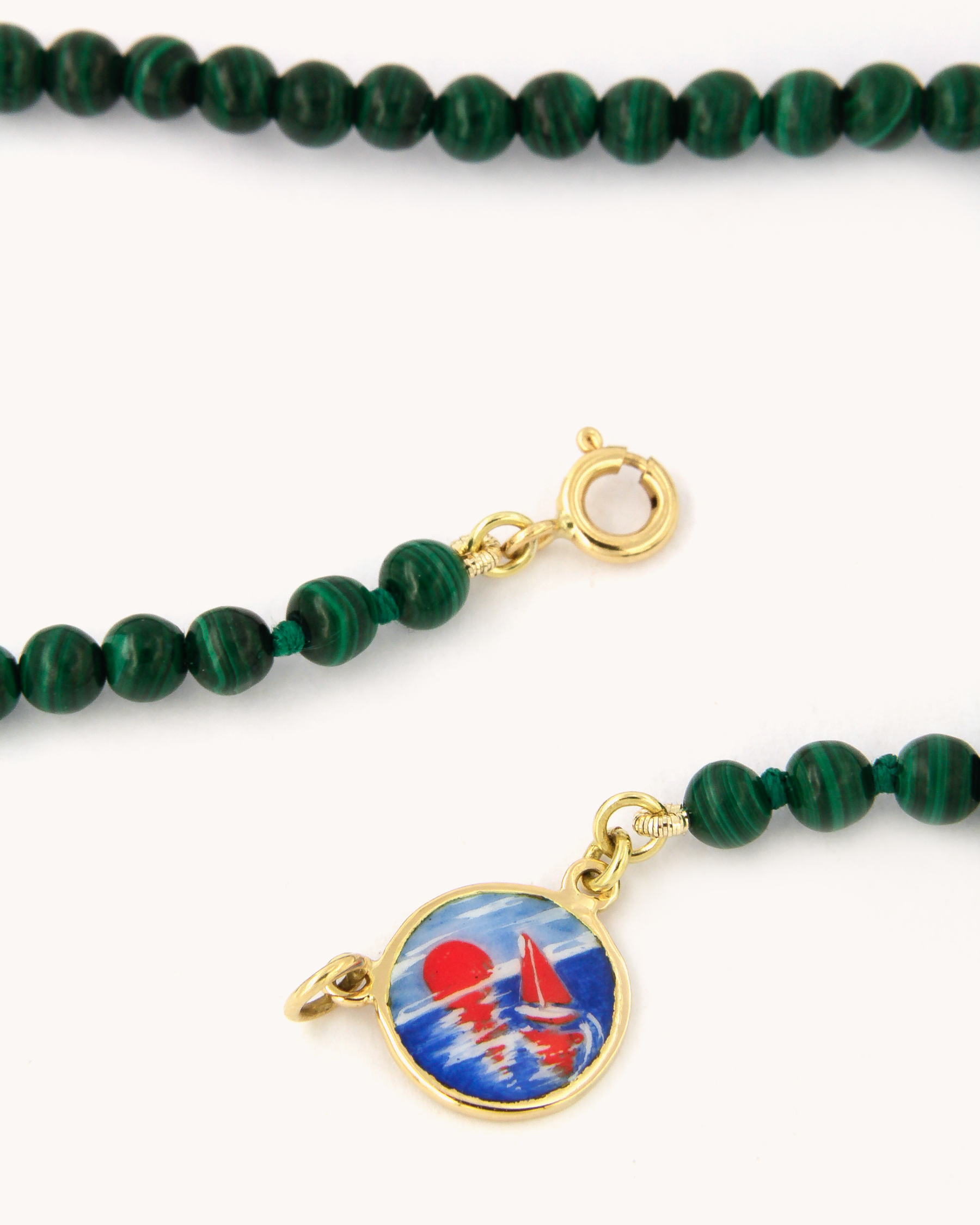 Dettaglio della Collana Coloris Tramonto in malachite, con piastra in oro giallo 18K e smalto a fuoco dipinto a mano.