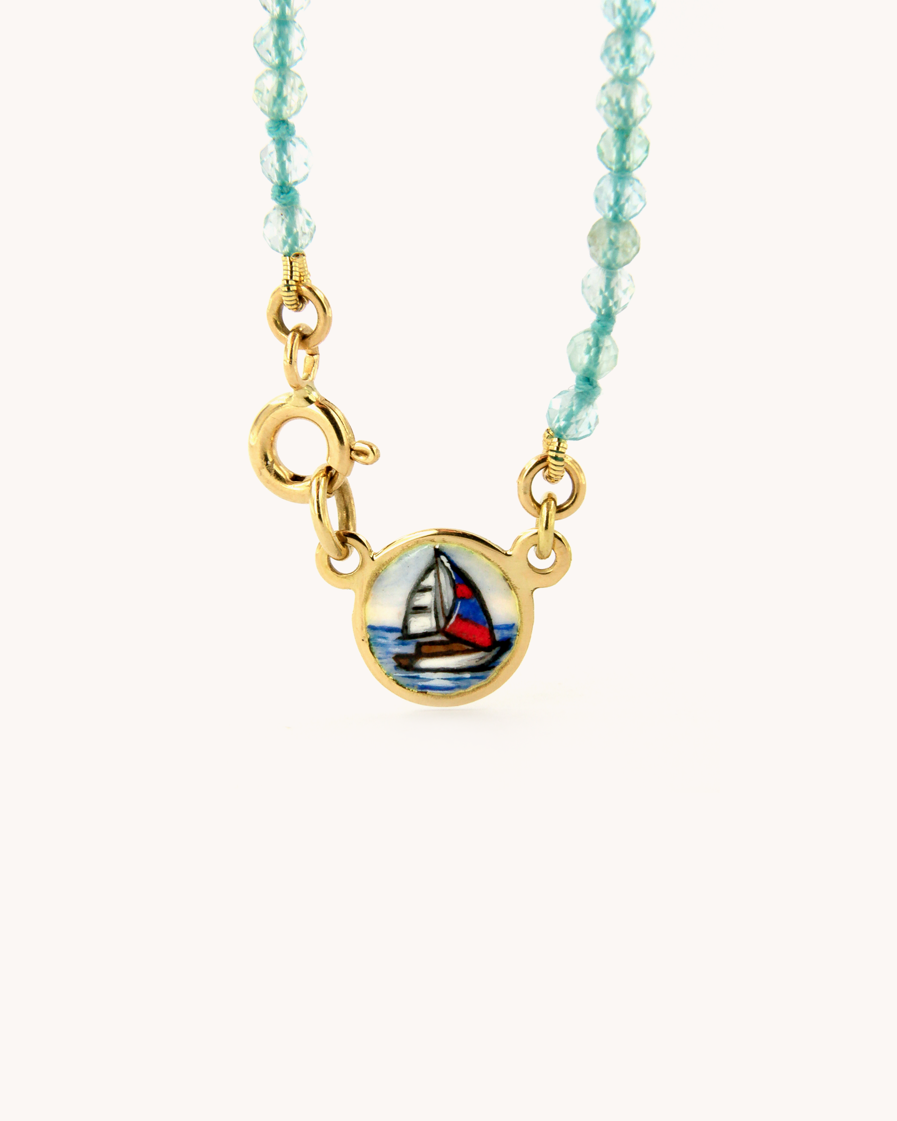 Dettaglio della Collana Coloris Vela con perline sfaccettate di apatite e piastrina in oro giallo 18 carati dipinta a mano in smalto a fuoco