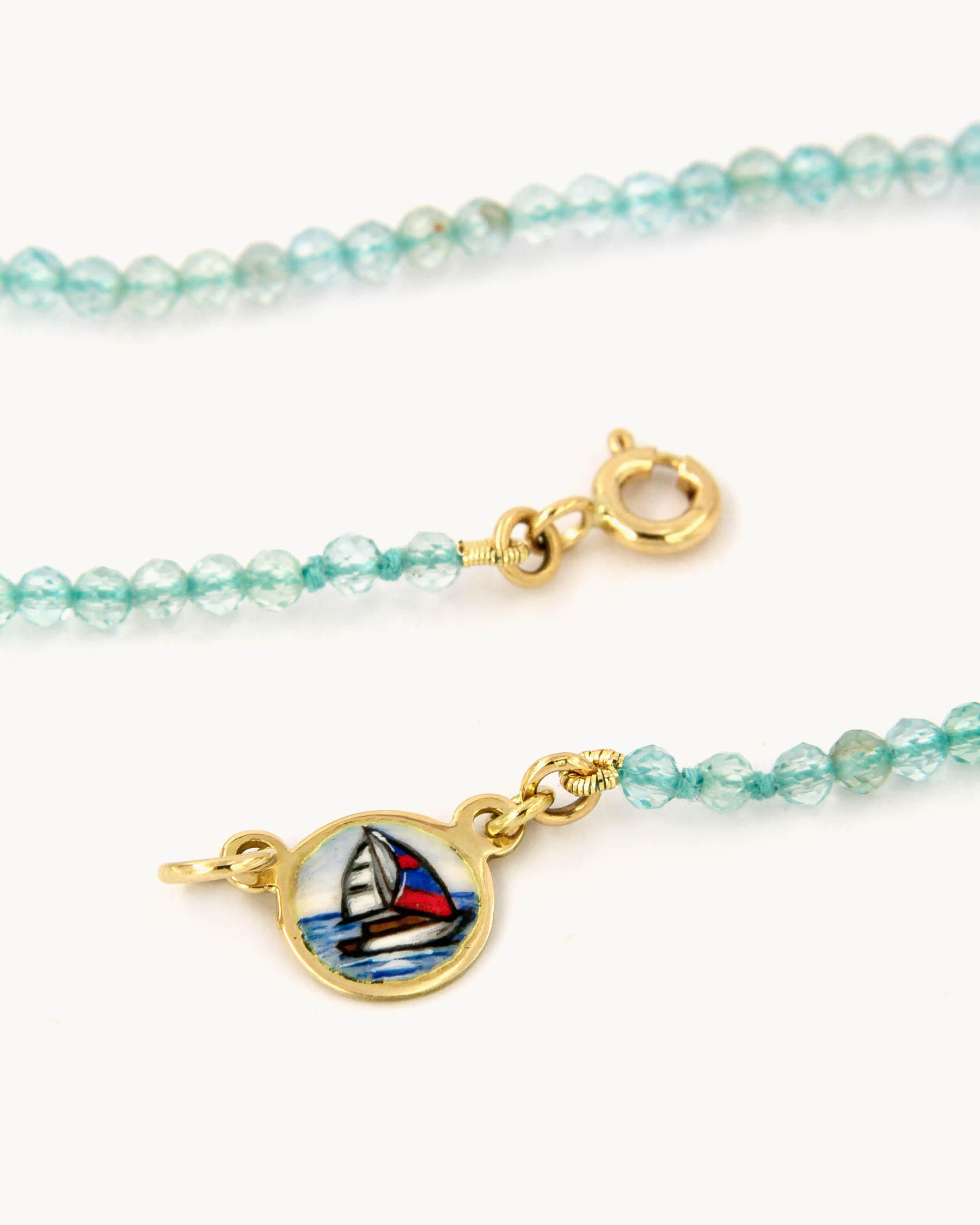 Dettaglio della Collana Coloris Vela con perline sfaccettate di apatite e piastrina in oro giallo 18 carati dipinta a mano in smalto a fuoco