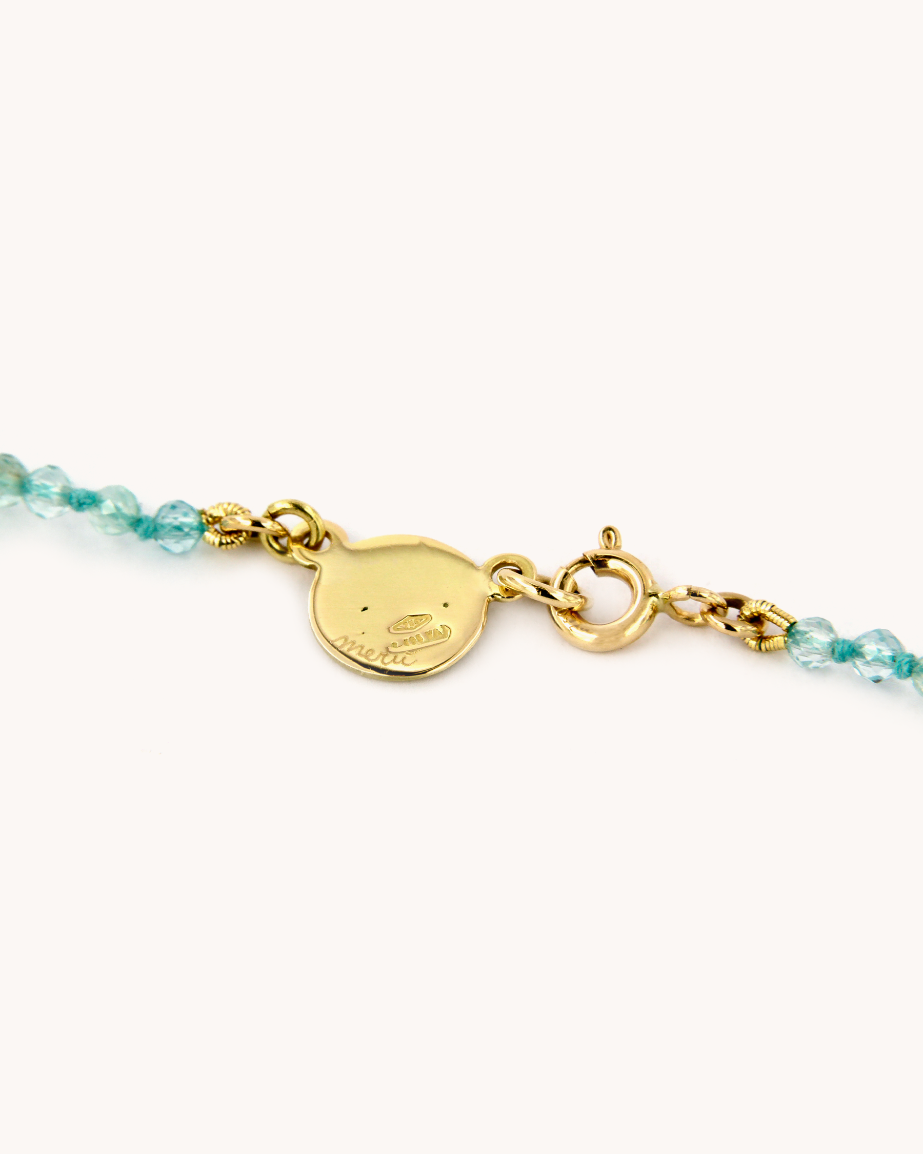 Dettaglio della Collana Coloris Vela con perline sfaccettate di apatite e piastrina in oro giallo 18 carati dipinta a mano in smalto a fuoco