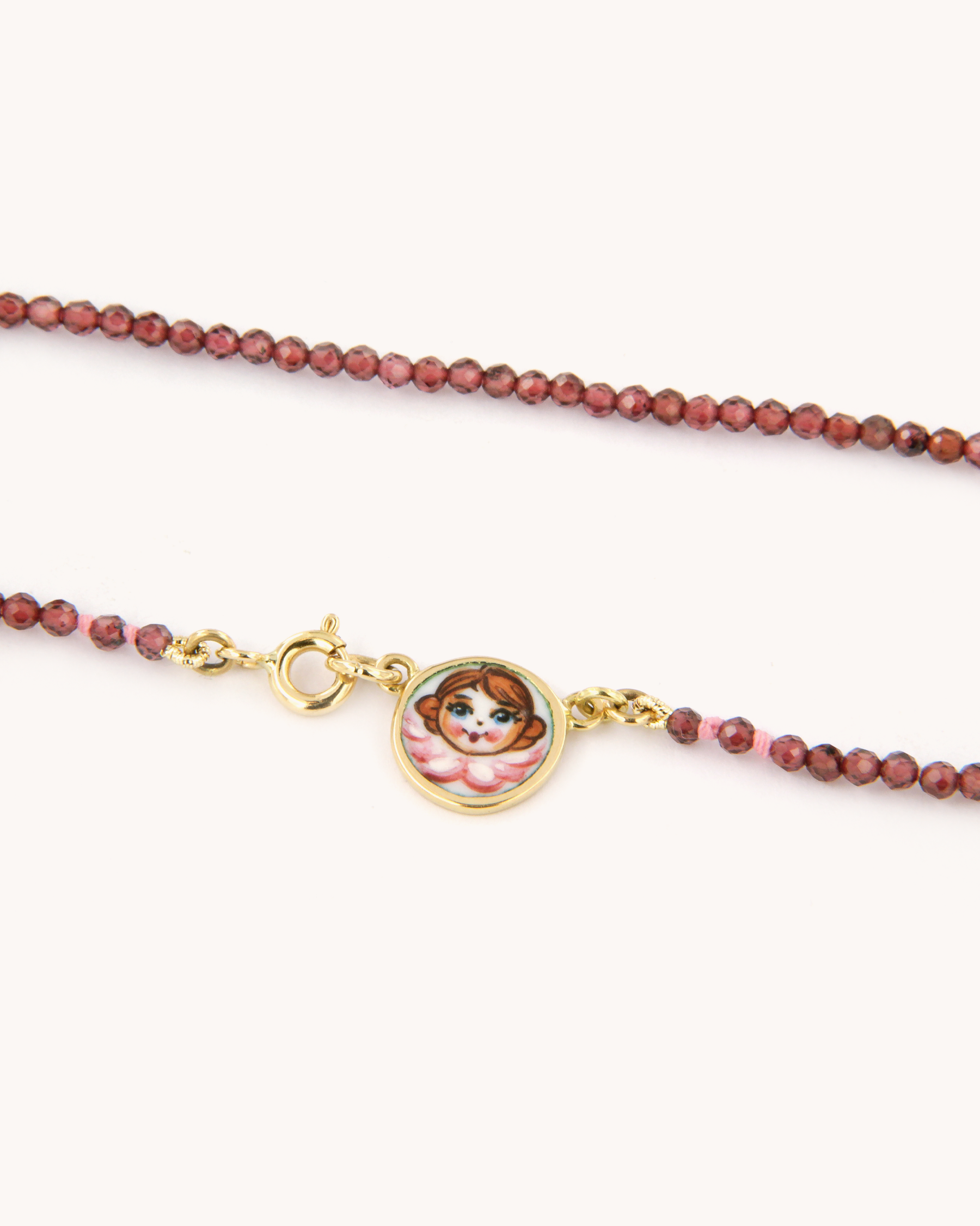 Collana con perline di granato e piastrina in oro 18 carati decorata con angelo in smalto a fuoco dipinto a mano – Merù Gioielli