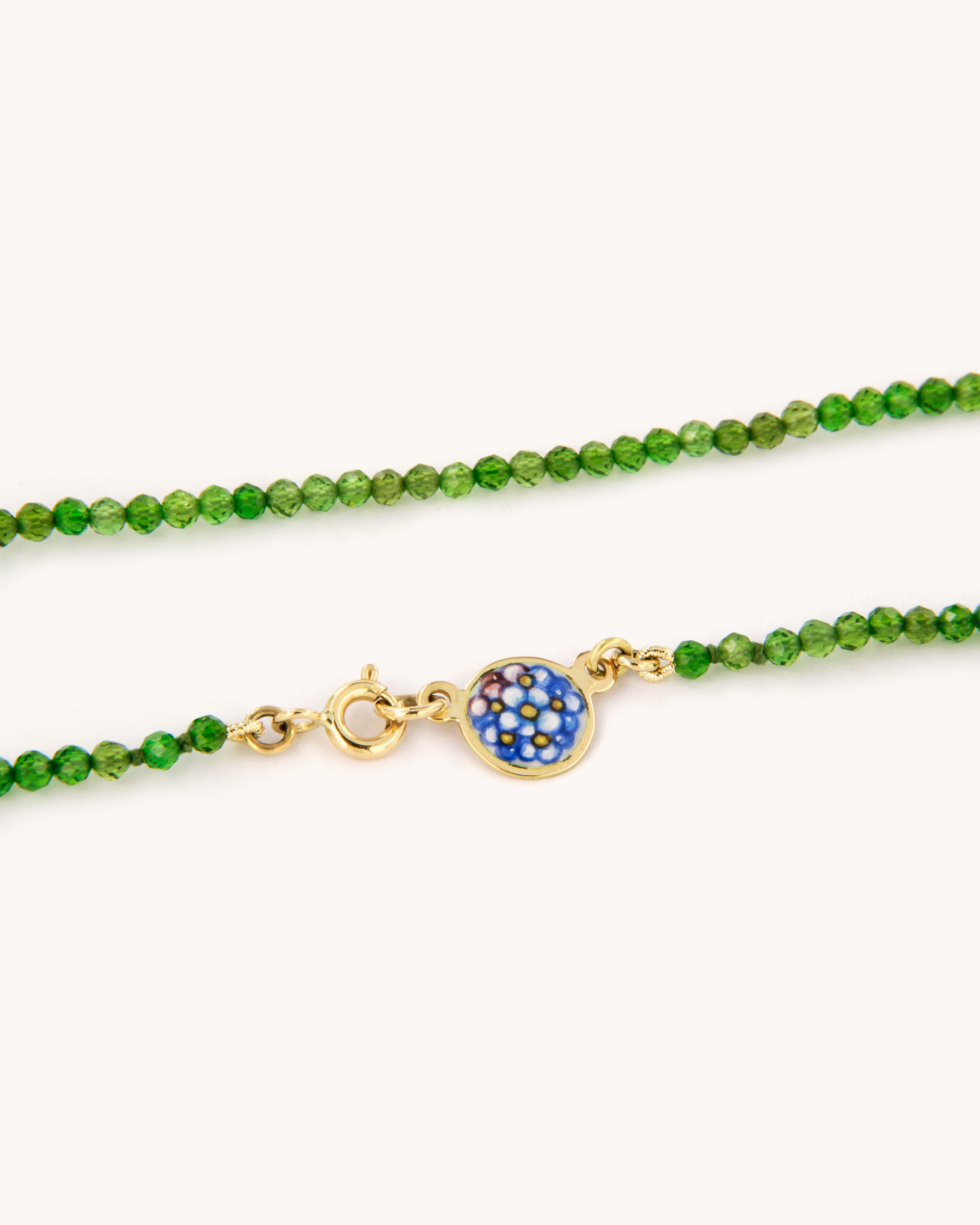 Collana in cromo diopside con piastrina in oro giallo 18 carati decorata con fiori “non ti scordar di me” in smalto a fuoco dipinto a mano.