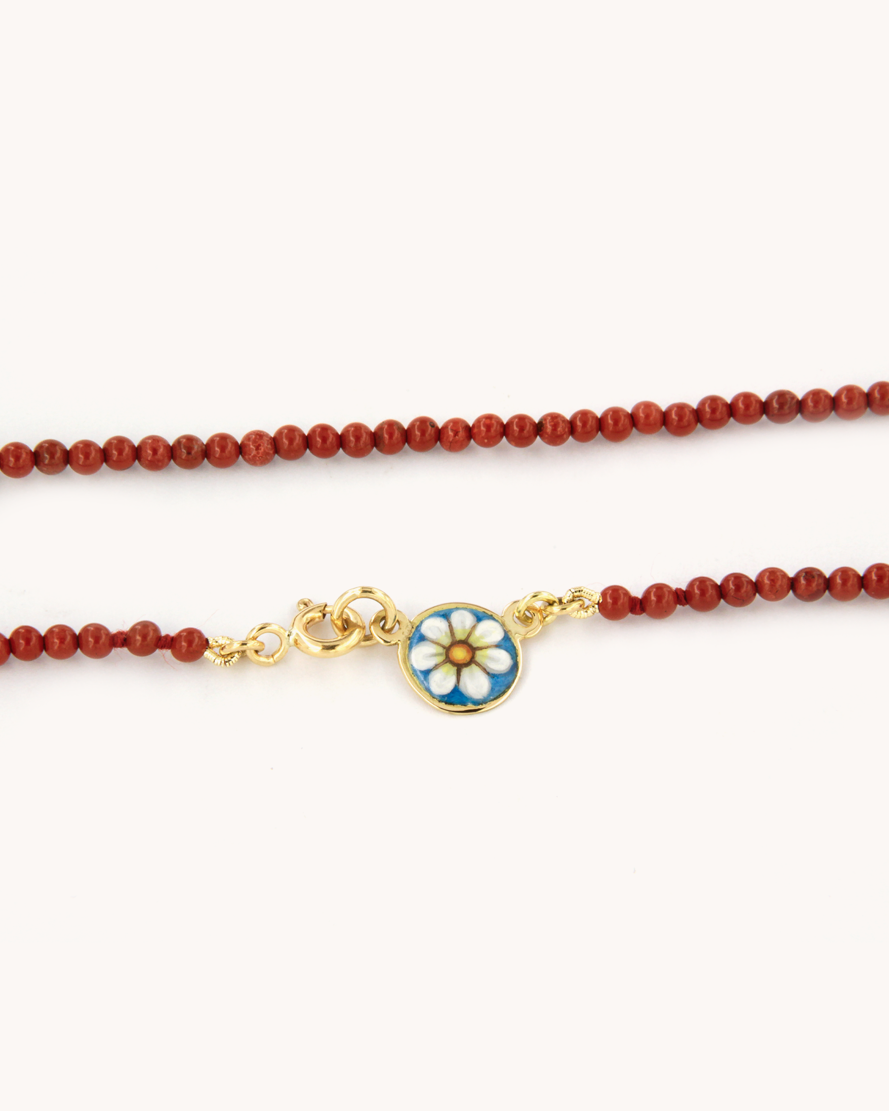 Collana con perle di diaspro rosso e piastrina in oro giallo 18K decorata con margherita in smalto a fuoco dipinto a mano.